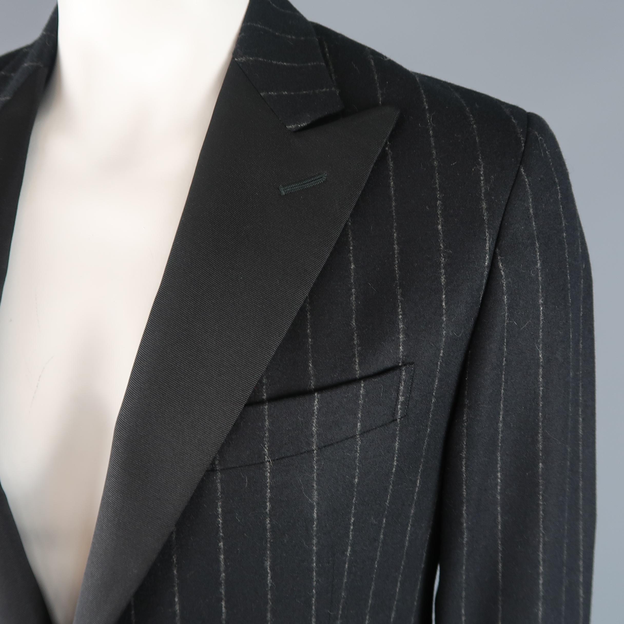 POLO RALPH  LAUREN sport coat comes in black chalkstripe wool cashmere with a single fabric button and faille tuxedo style peak lapel. Made in Italy.
Retail: $1200.00
Excellent Pre-Owned Condition.
Marked: 42
 
Measurements:
    Shoulder: 18 in.
   