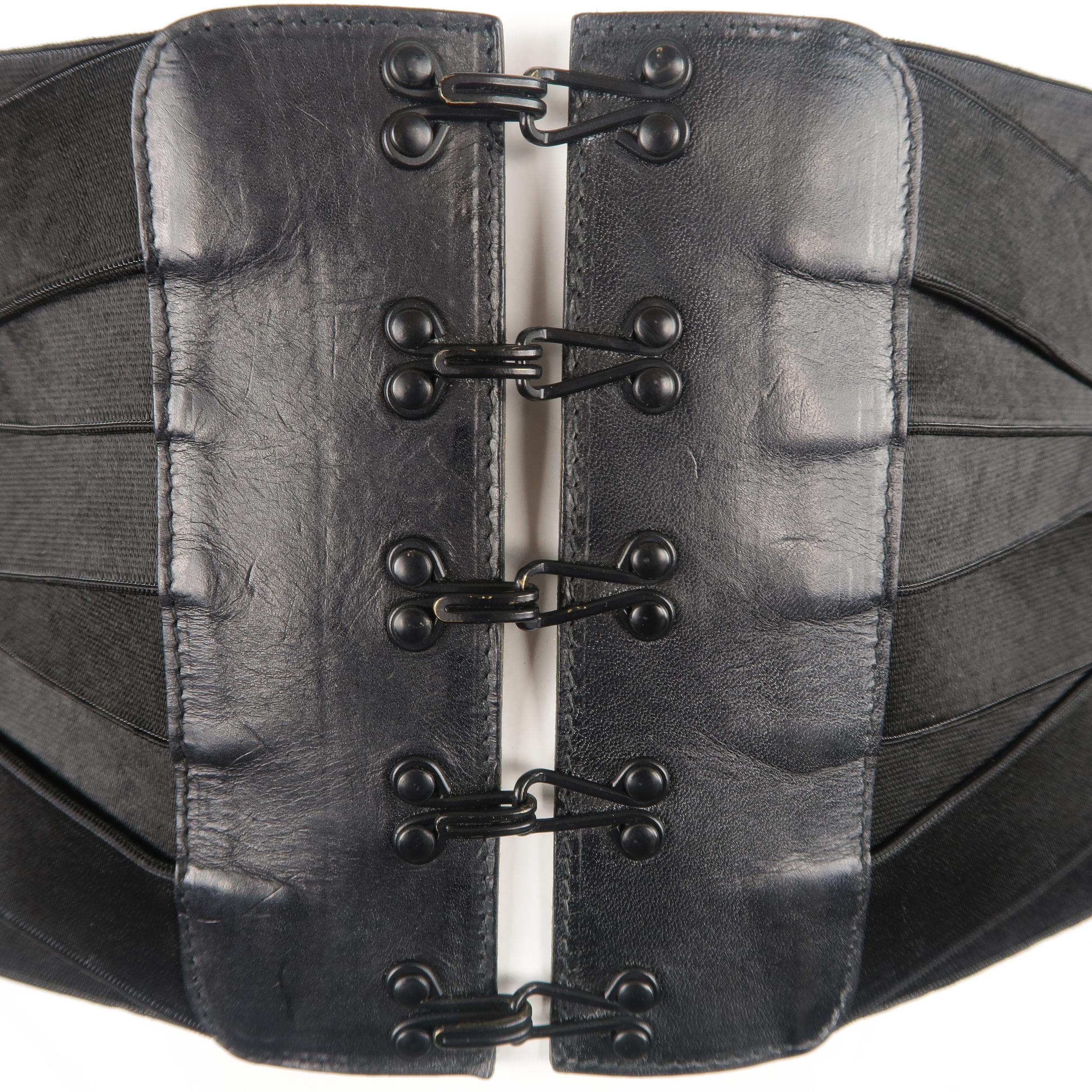 This rare vintage Jean Paul Gaultier  corset belt features eight directionally placed weave effect elastic stretch bands with a leather detailed, oversized hook eye closure. Minor wear on hardware.
 
Good Pre-Owned Condition.
Marked: IT 50
