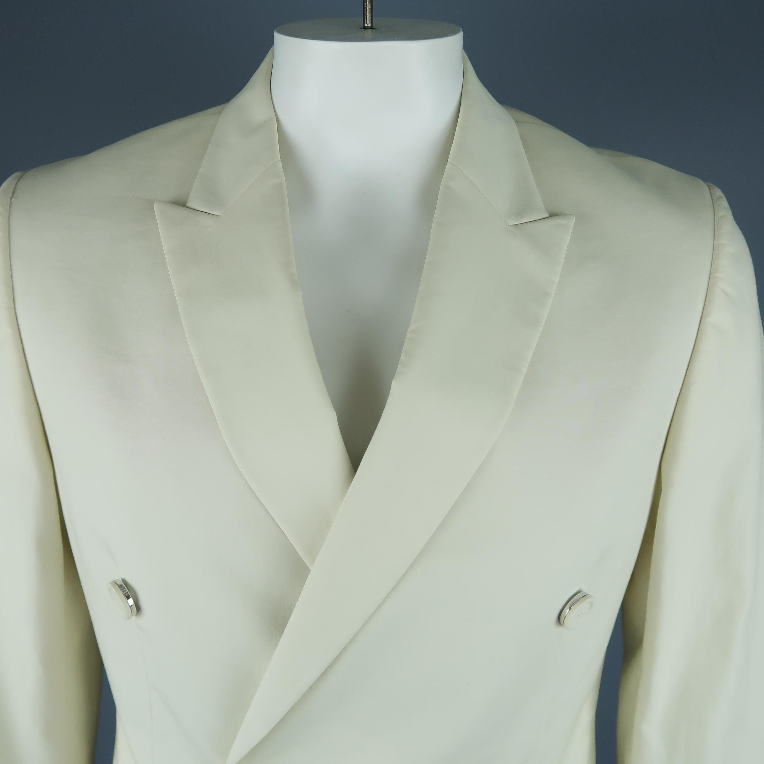 Double breasted CALVIN KLEIN COLLECTION sport coat comes in light weight bone beige bonded cotton with a peak lapel fabric faced, silver tone metal buttons, and flap pockets. Made in Italy.
 
New with Tags.
Marked: IT 52
 
Measurements:
 
Shoulder: