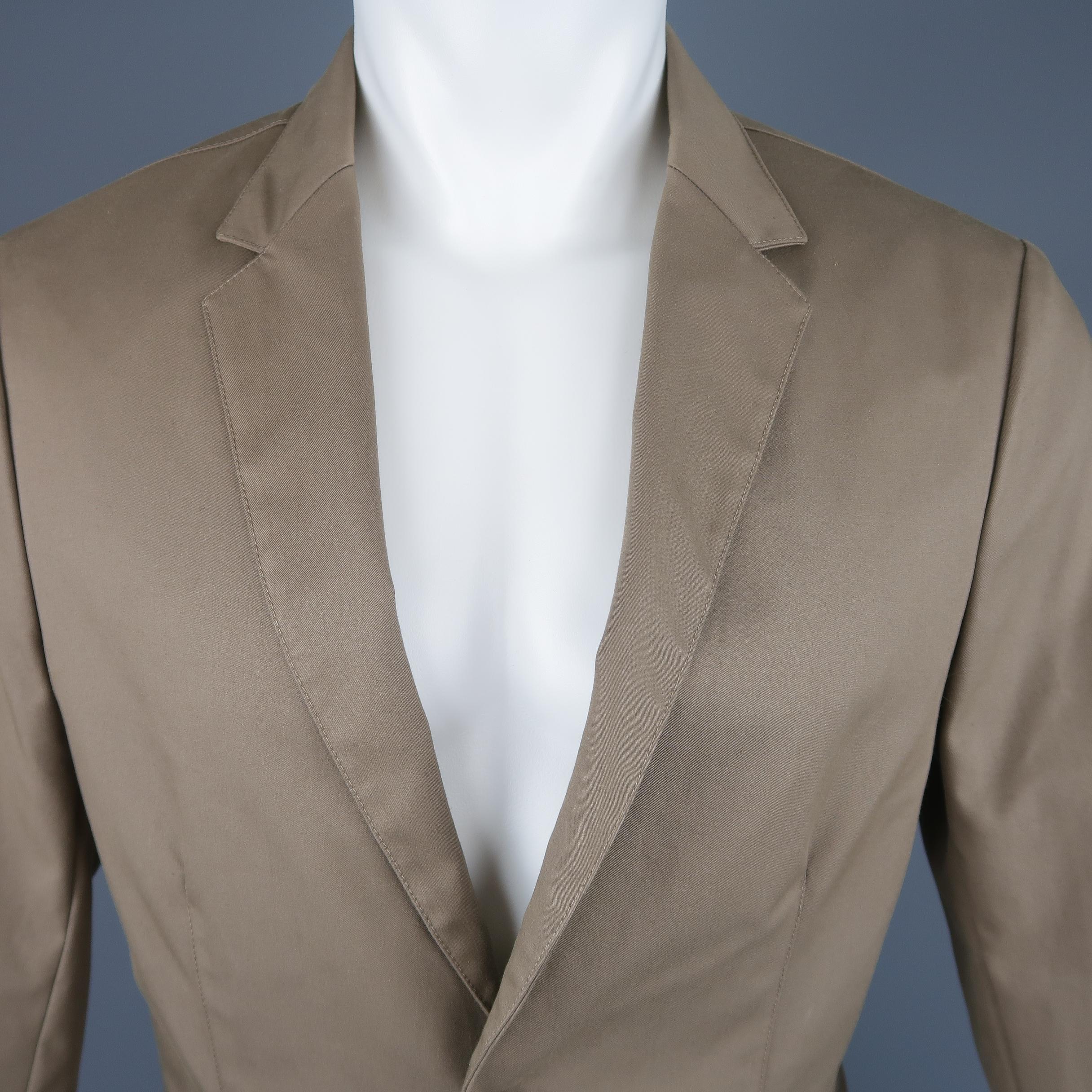 Single breasted CALVIN KLEIN COLLECTION monochromatic sport coat jacket comes in taupe cotton blend structured fabric with a notch lapel, two button front, and ventless back. Made in Italy.
 
New with tags
Marked: IT 48
 
Measurements:
 
Shoulder: