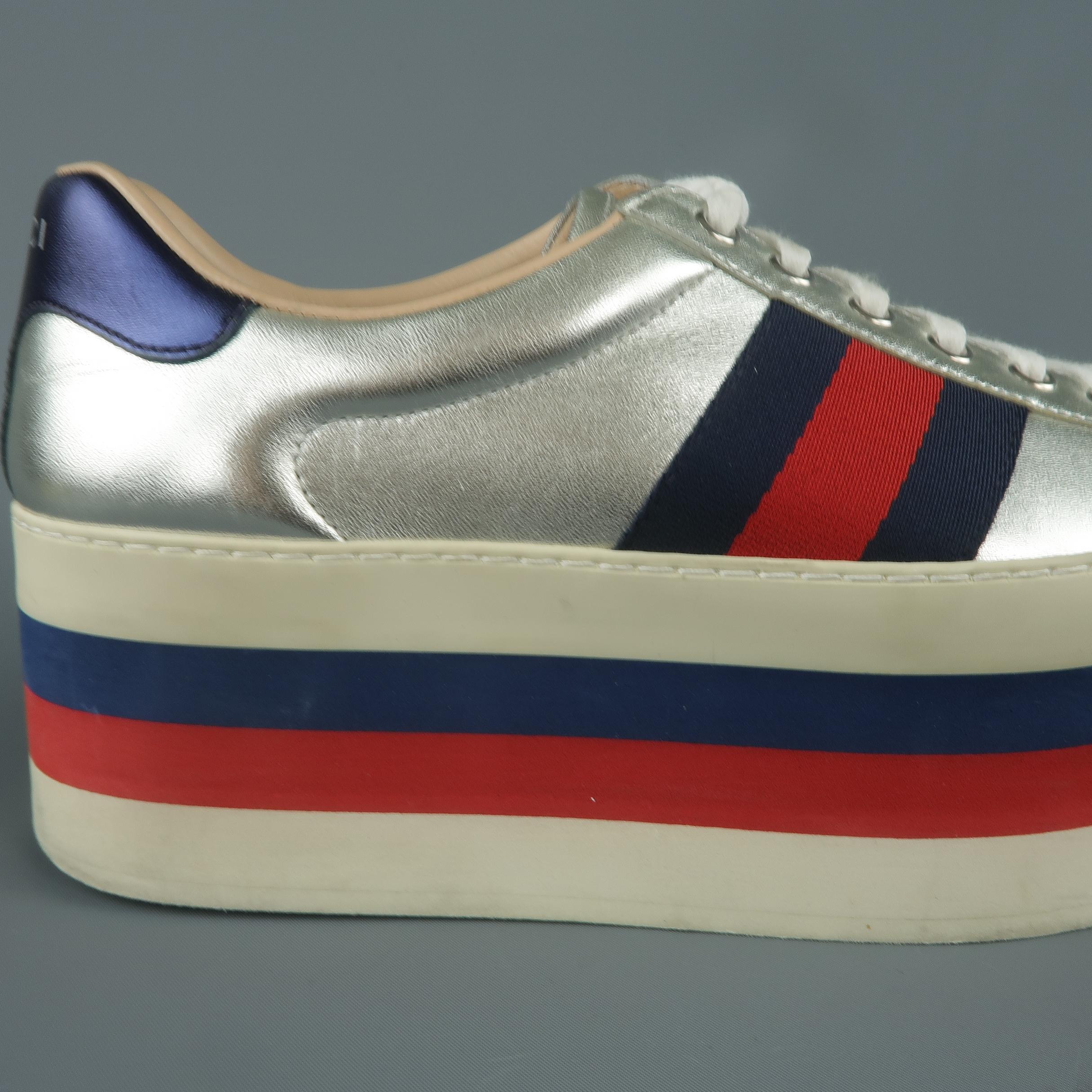 GUCCI platform sneakers come in metallic silver leather with signature grosgrain webbing, metallic red and navy heels, and striped platform sole. Made in Italy.
 
Good Pre-Owned Condition.
Marked: UK 7
 
Platform: 2.5 in.