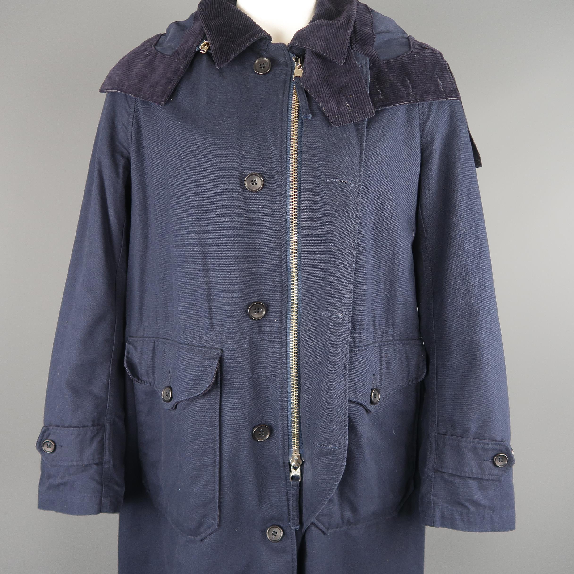 Engineered Garments coat comes in navy blue canvas with a corduroy pointed collar, zip closure with button placket, patch flap pockets, zip off hood, and detachable wool knit liner. Made in New York.
 
Good Pre-Owned Condition.
Marked: XL
