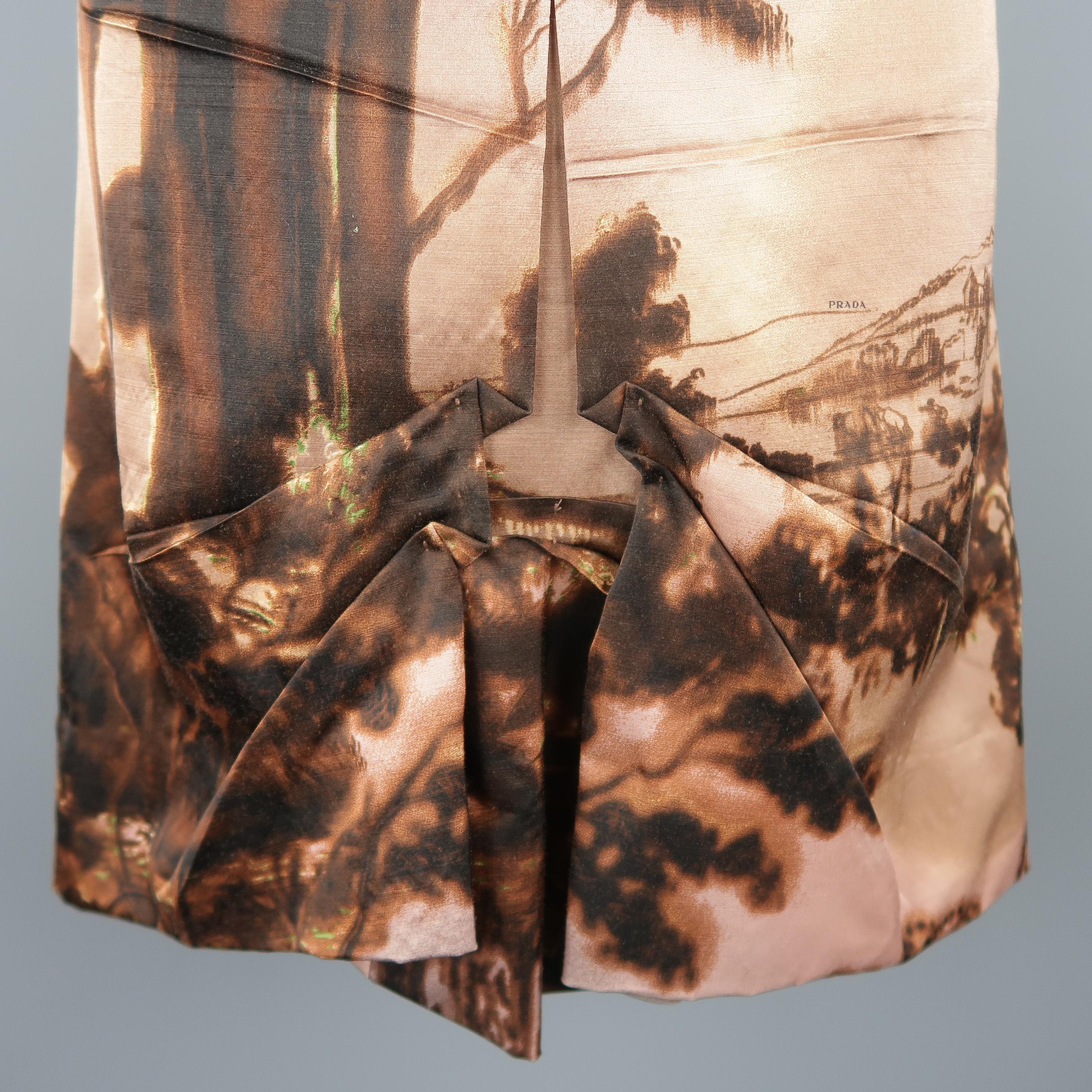 This Prada A-line skirt comes in muted pink and brown wool silk blend matte satin with a landscape graphic print motif and symmetrical Origami pleated front. Made in Italy.
 
Excellent Pre-Owned Condition.
Marked: IT 38
 
Measurements:
 
Waist: 27