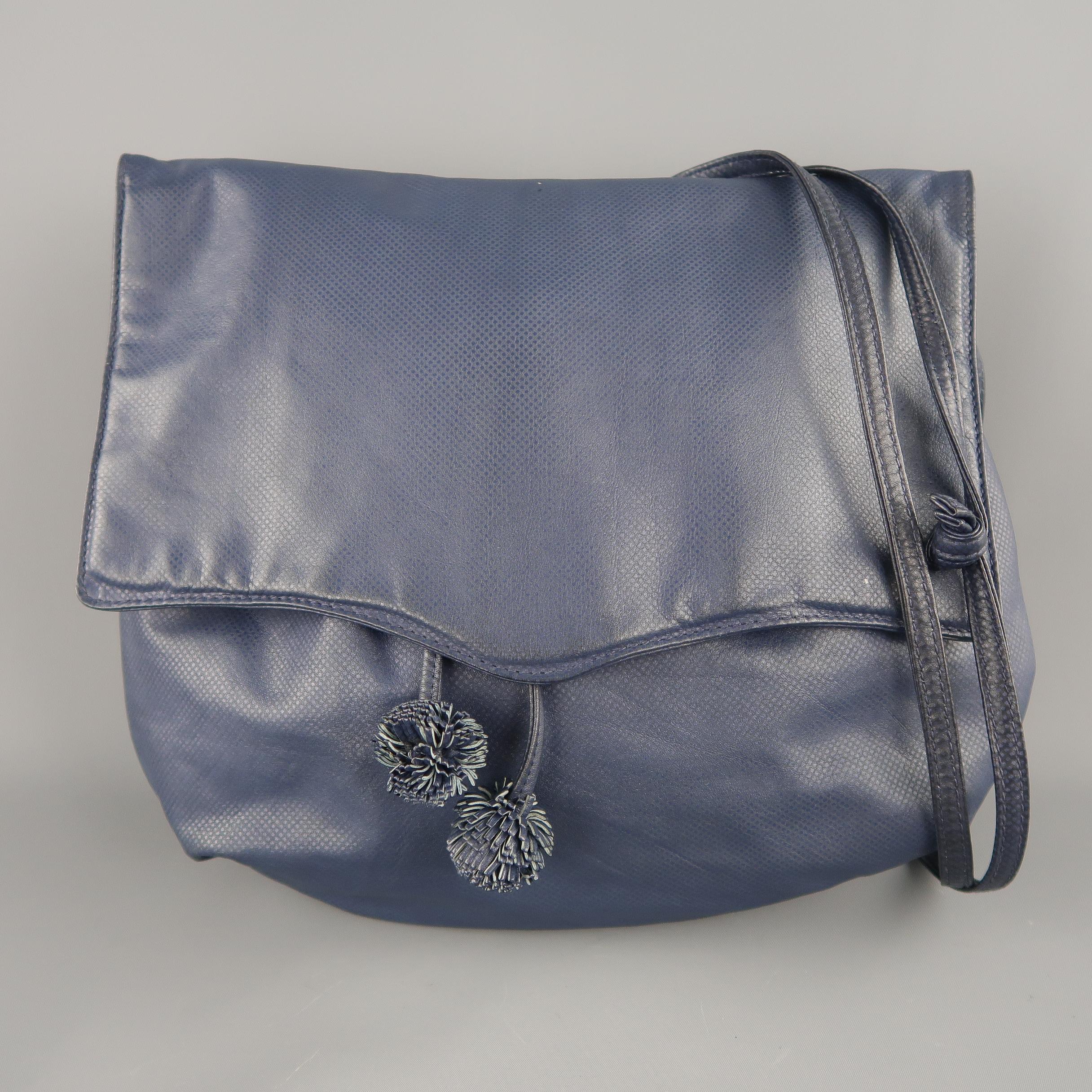 Vintage Bottega Veneta handbag comes in textured navy blue leather with a top flap, frontal compartment with gathered top, double ball tassels, double skinny straps, and leather interior with zip pocket. Includes Mirror. Discolorations on sides.
