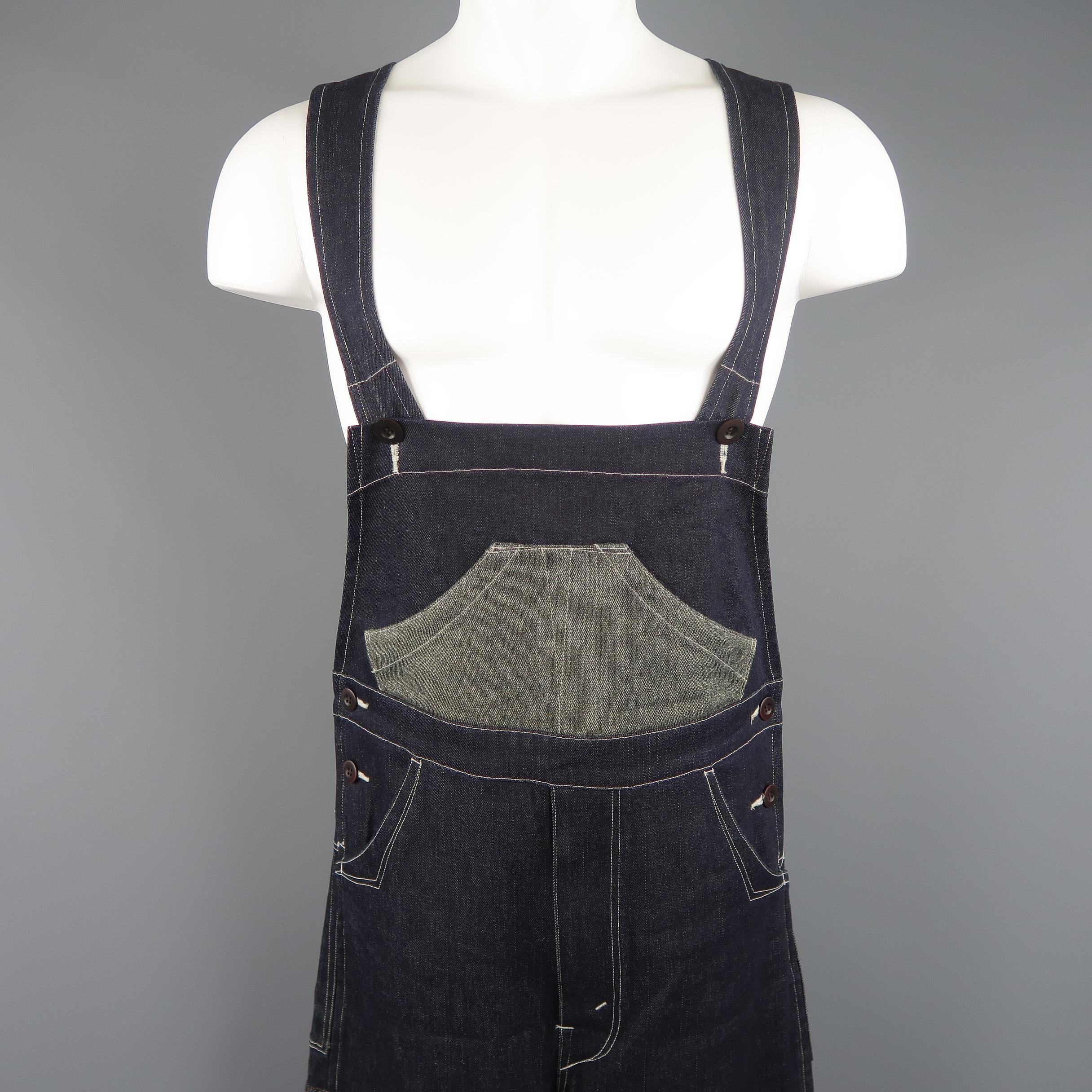 JUNYA WATANABE MAN COMME des GARCONS overalls come in classic indigo blue denim with contrast stitch details, adjustable straps, and brown glenplaid patches. Made in Japan.
 
Excellent Pre-Owned Condition.
Marked: XS
 
Measurements:
 
Waist: 35