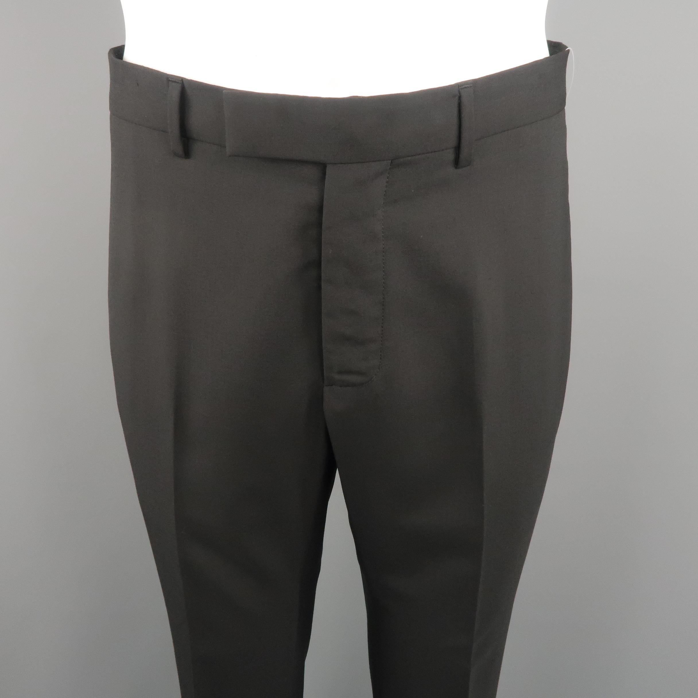 DIOR HOMME dress pants come in black tone in solid wool material with waistband, slant side pockets and cuffed hem. Made in Italy.
Excellent Pre-Owned Condition.
Marked: 48  IT
 
Measurements:
 
Waist: 34 in.
Rise: 9 in.
Inseam: 31 in.