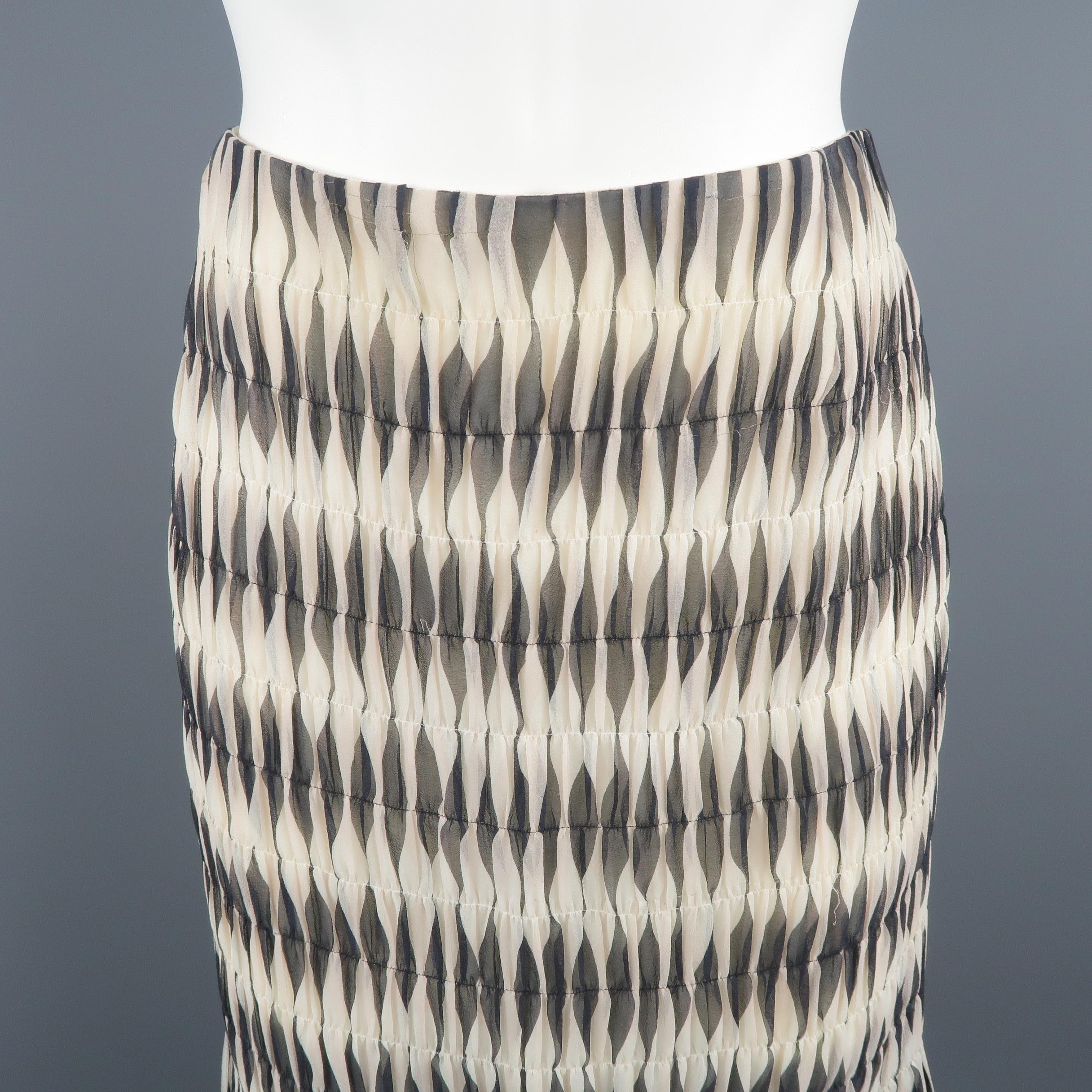 AKRIS A-line skirt, come in black and white tones, geometric print in silk chiffon material, and lateral zipper. Small signals of use, with a little bit of peeling on the top. Made in Switzerland.
 
Good Pre-Owned Condition.
Marked: 8 US
