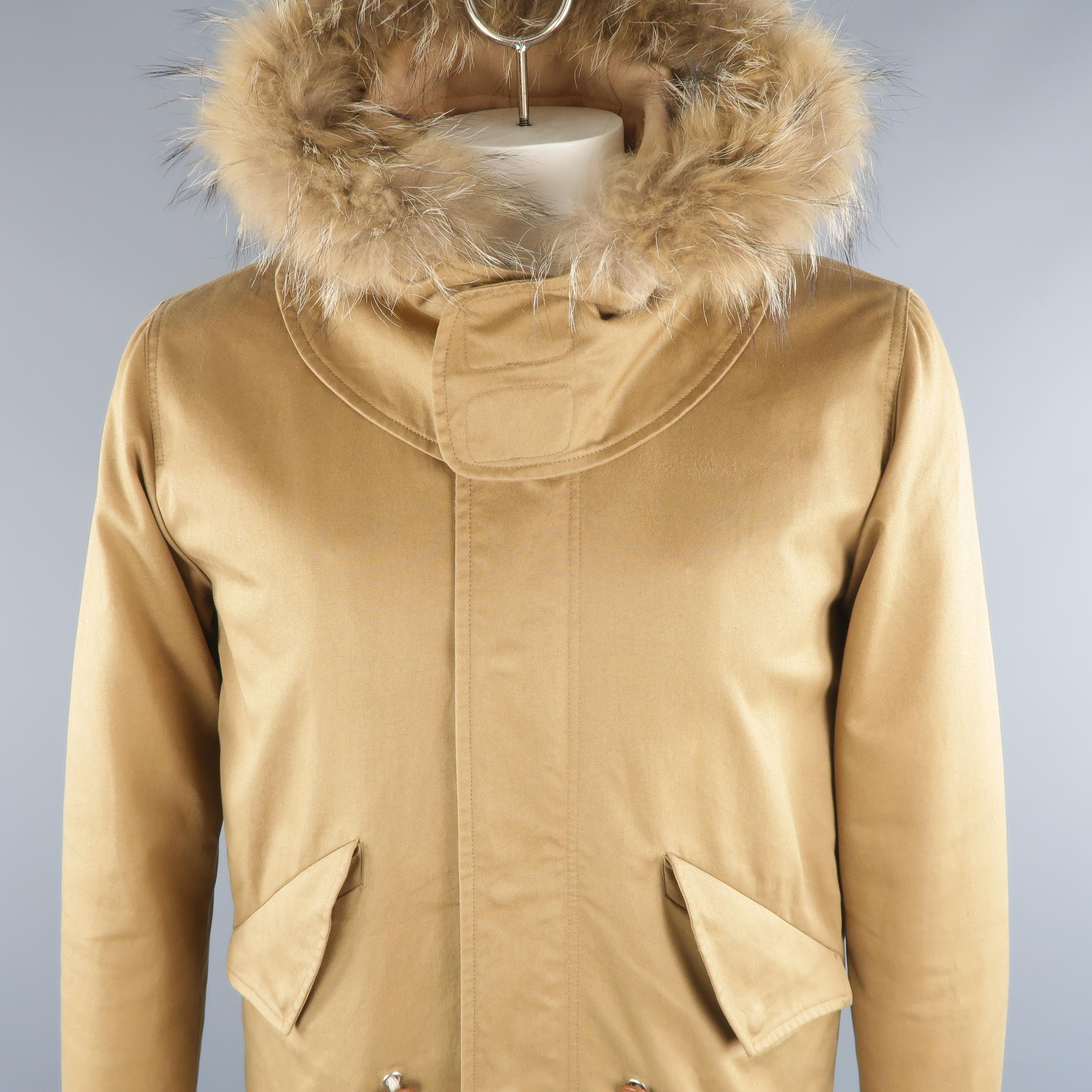 SANDRO jacket come in tan tone in solid cotton material, with detachable hood with fur trim, quilted detachable lining and front large flap pockets, zip & snaps. Small signals of use throughout.
 
Excellent Pre-Owned Condition.
Marked: L
