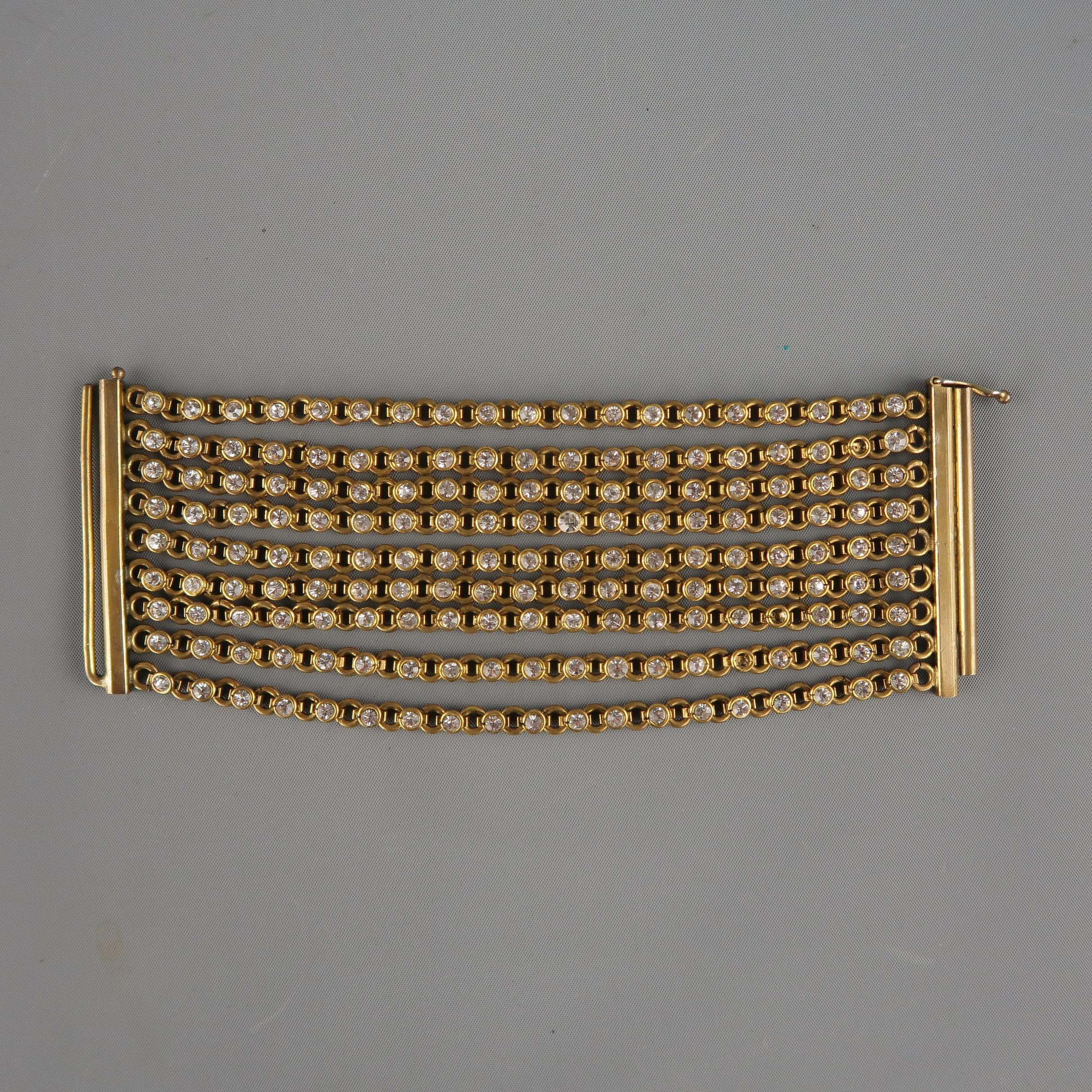 Vintage Mid-century CHANEL cuff bracelet comes in antique gold tone bras and features nine rows of white rhinestone chain strands with rod clasp closure. Minor wear on closure and missing three stones.  Includes a Chanel dust bag.
 
Vintage