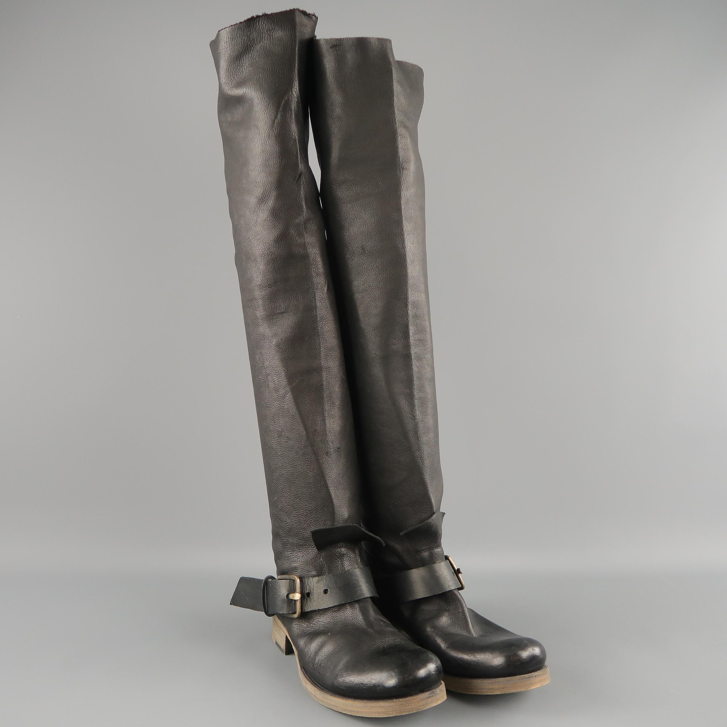 GUIDI thigh high biker boots come in textured leather with a round toe, stacked beige heeled sole, thick ankle strap with buckle, tongue, and raw edge hem at top. Made in Italy.
 
Excellent Pre-Owned Condition. Retails: $2,090.00.
Marked: IT 37
