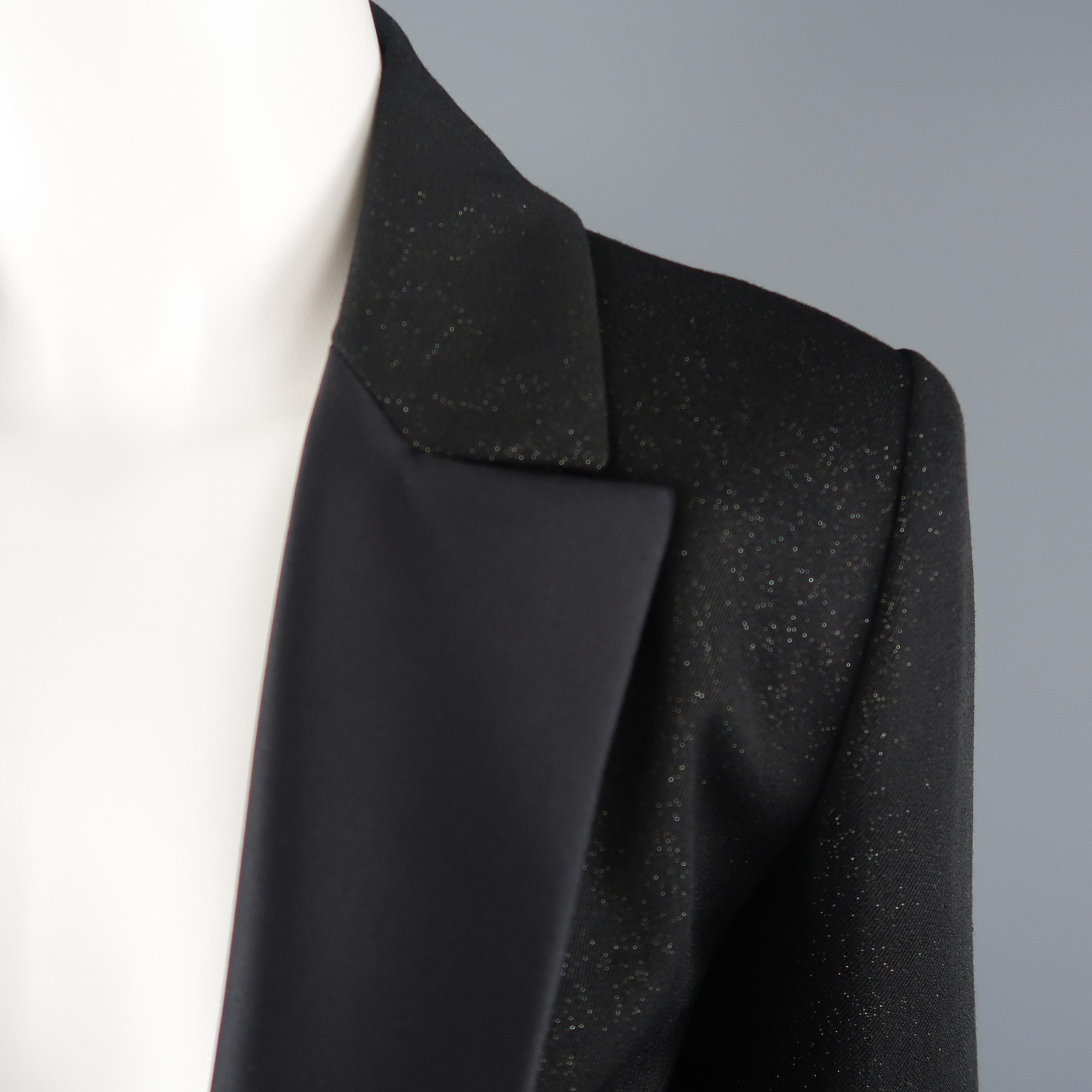 CHANEL tuxedo style jacket comes in a black wool blend twill with an all over glitter sheen and features a half silk satin peak lapel, single button front with rhinestone enamel chain closure, and functional button cuffs. Made in France.
 
Excellent