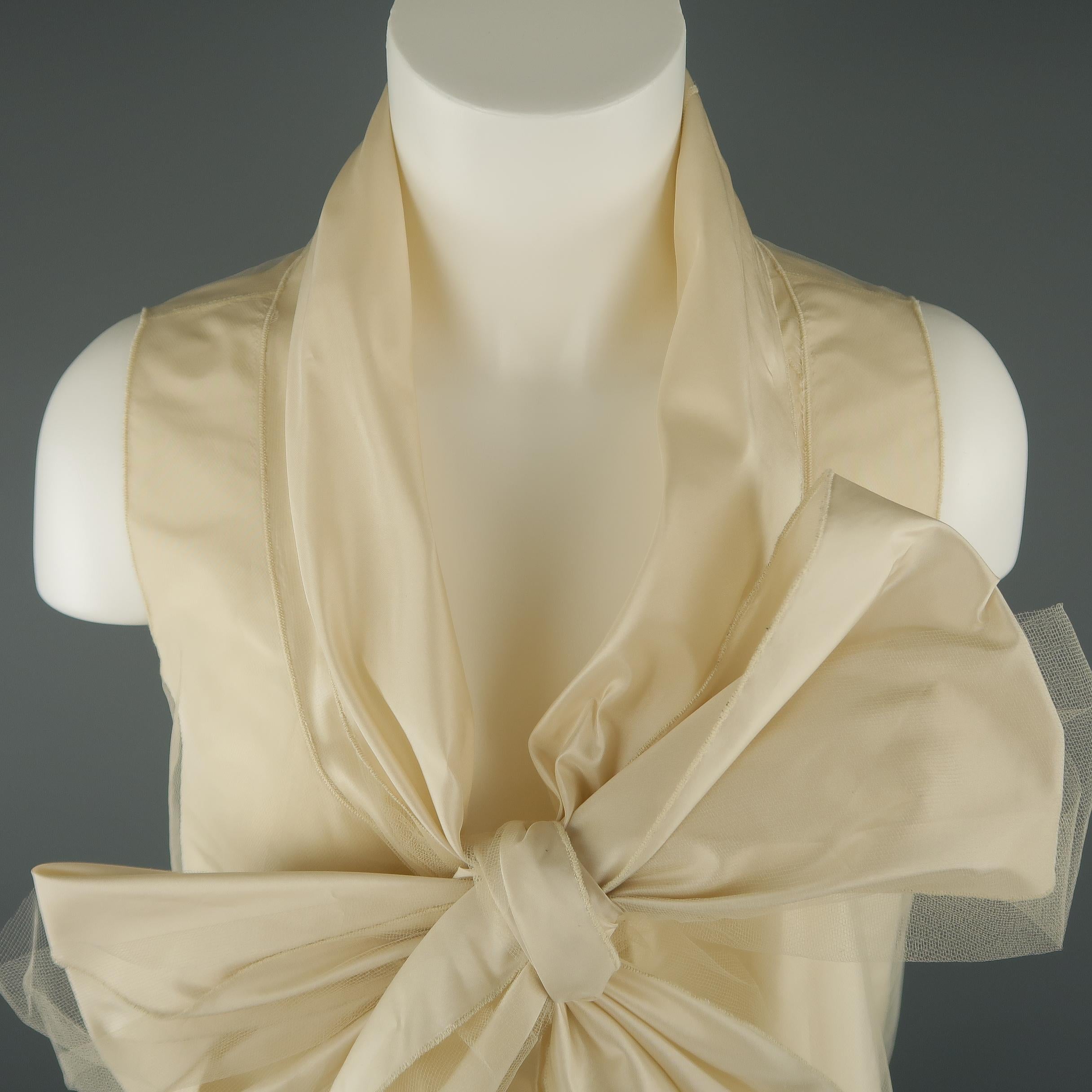 OSCAR DE LA RENTA sleeveless blouse comes in silk taffeta and features an A line body with tulle overlay, lace trim, and shawl collar with oversized bow tie front. Discolorations shown in detail shots. As-is. Circa Spring 2006. Made in USA.
 
Good