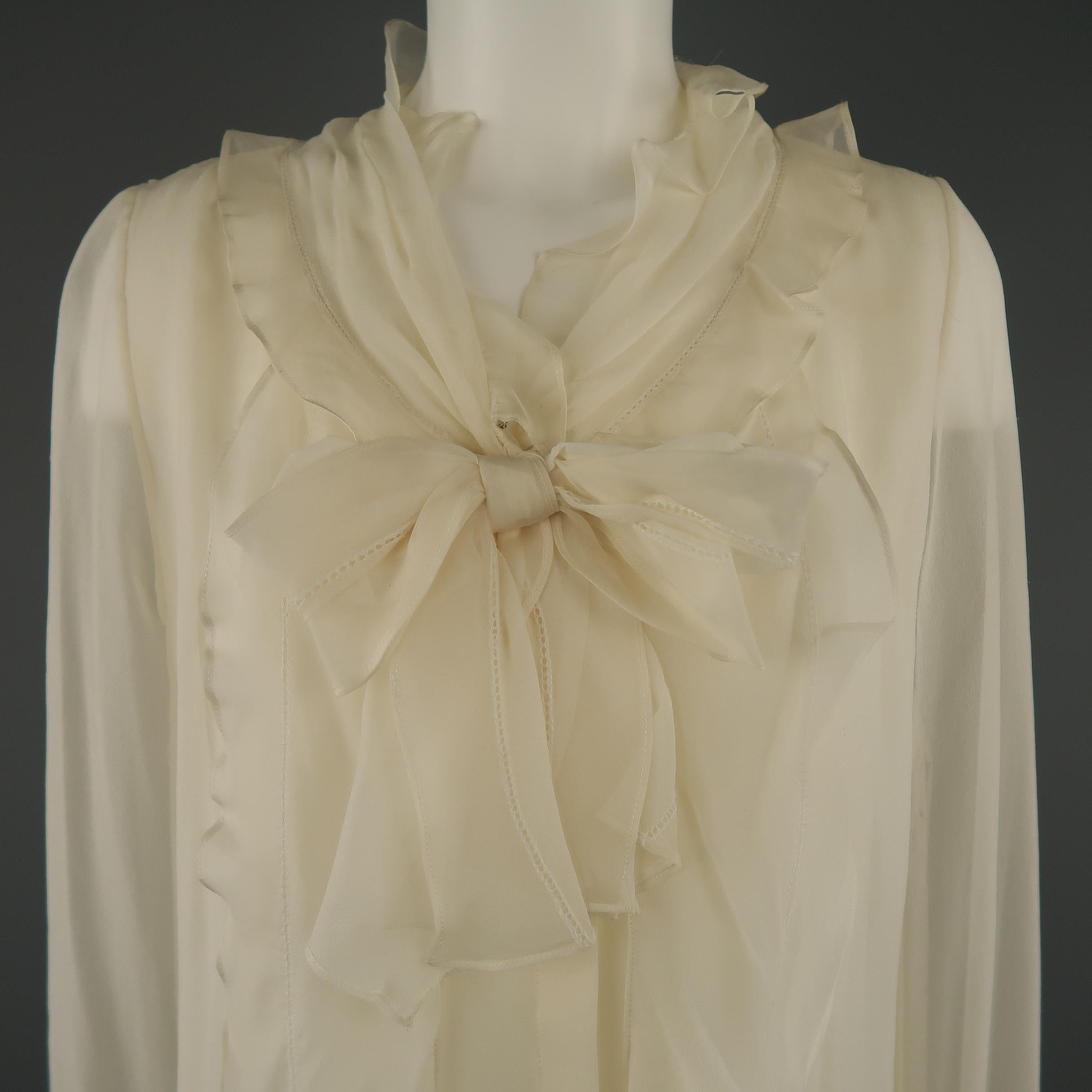 OSCAR DE LA RENTA blouse comes in cream silk chiffon with a round ruffled collar, bow accent, and hidden placket closure. Imperfections in material on sleeves and stain on back. As-is. With tags. Made in USA.
 
Good Pre-Owned Condition.
Marked: 8
