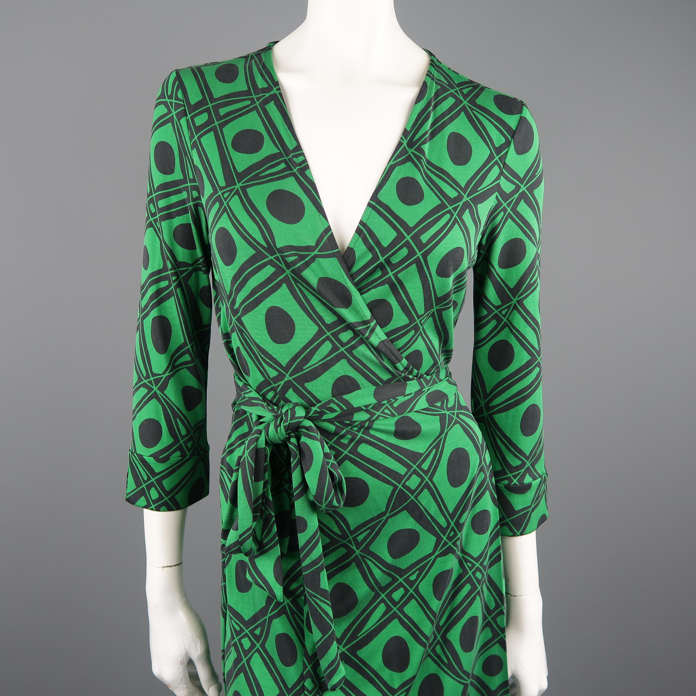 DIANE VON FURSTENBERG Vintage wrap dress comes in green and black retro geometric print silk jersey with a deep v neck, adjustable wrapped tie closure, and slit cuffed three quarter sleeves.
 
Vintage Pre-Owned Condition.
Marked: 12
 
Measurements:
