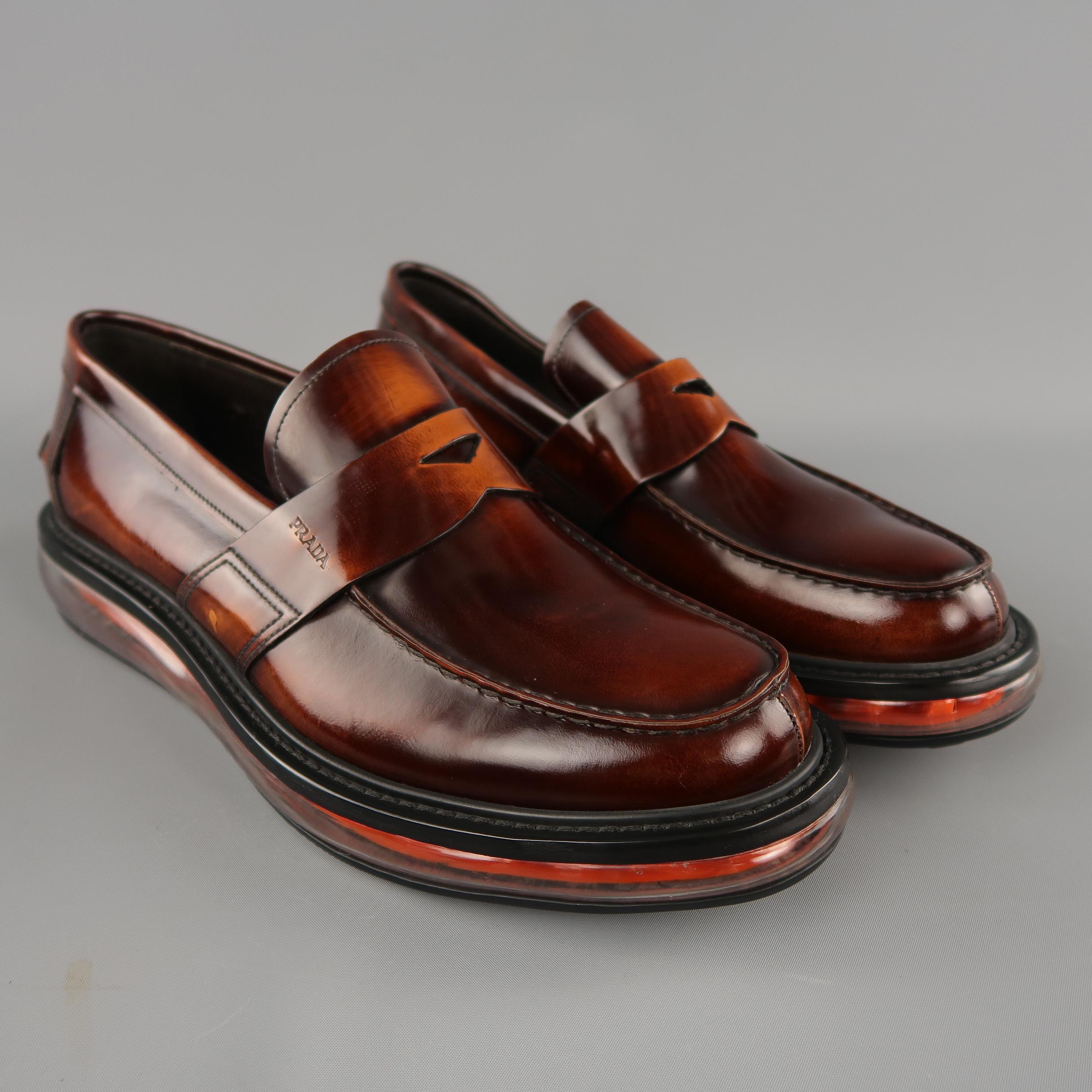PRADA penny loafers come in antique brown patent leather with an apron sole and orange levitate sole. Made in Italy.  Retails: $880
 
Excellent Pre-Owned Condition.
Marked: UK 10 1/2
 
Outsole: 12.5 x 4.5 in.
Sole: 1 in.