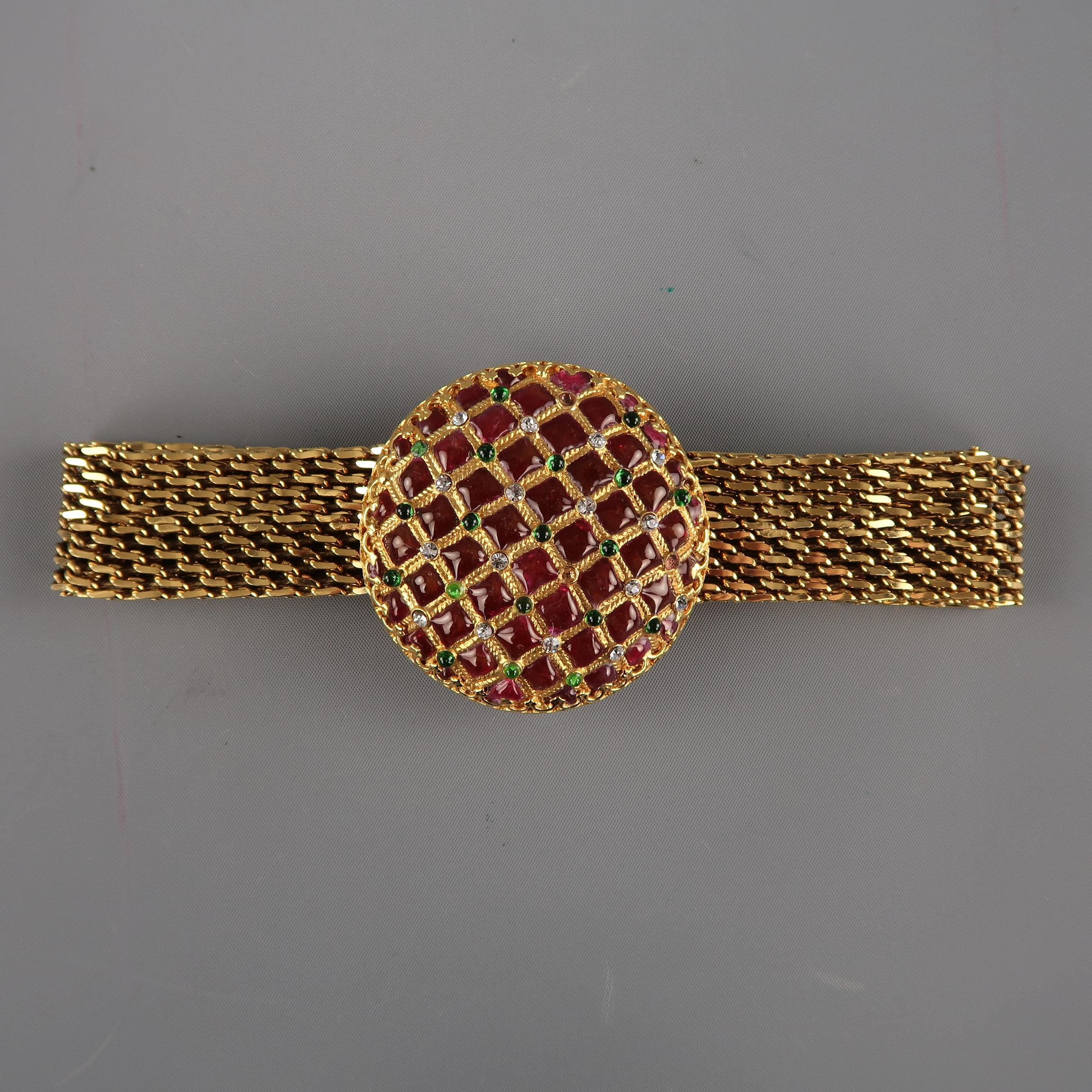 Vintage CHANEL circa Autumn 1997 statement belt comes in gold tone metal and features a crochet strap and round tufted effect Byzantine buckle with burgundy enamel, green gems, and clear rhinestones. Missing three stones. As-is. Made in France.

