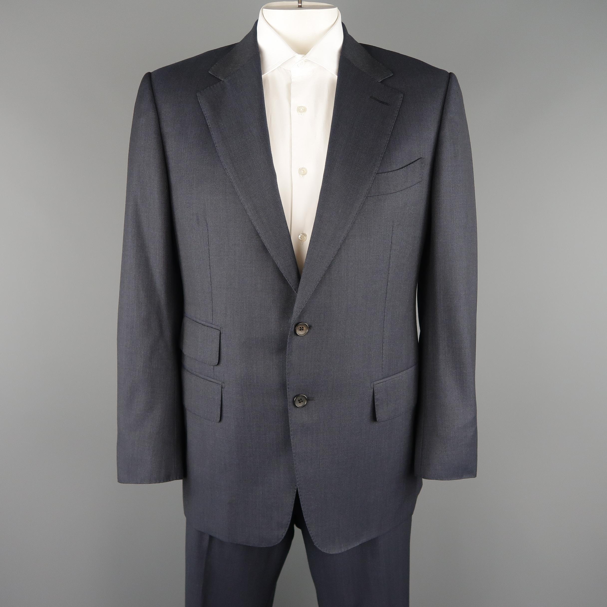 TOM FORD suit comes in woven navy blue wool material and includes a single breasted, notch lapel, two button, silk lined sport coat with functional button cuffs and matching flat front trousers with signature side tabs. 

Made in Switzerland.