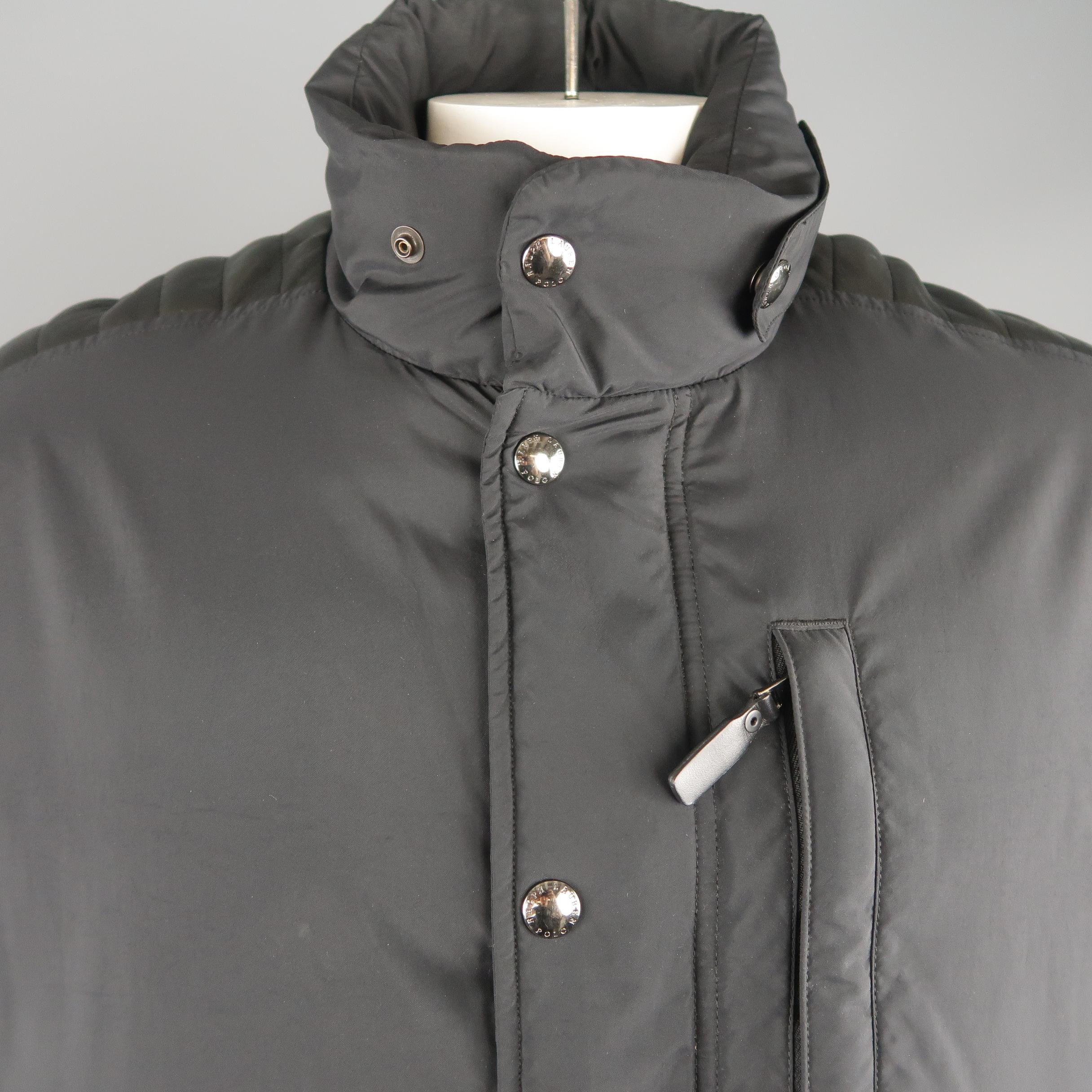 POLO RALPH LAUREN down filled puffer jacket comes in black quilted nylon with a high collar, zip closure with hidden snap placket zip pockets, quilted leather arm stripe, and red perforated leather underarm panel.
 
Excellent Pre-Owned