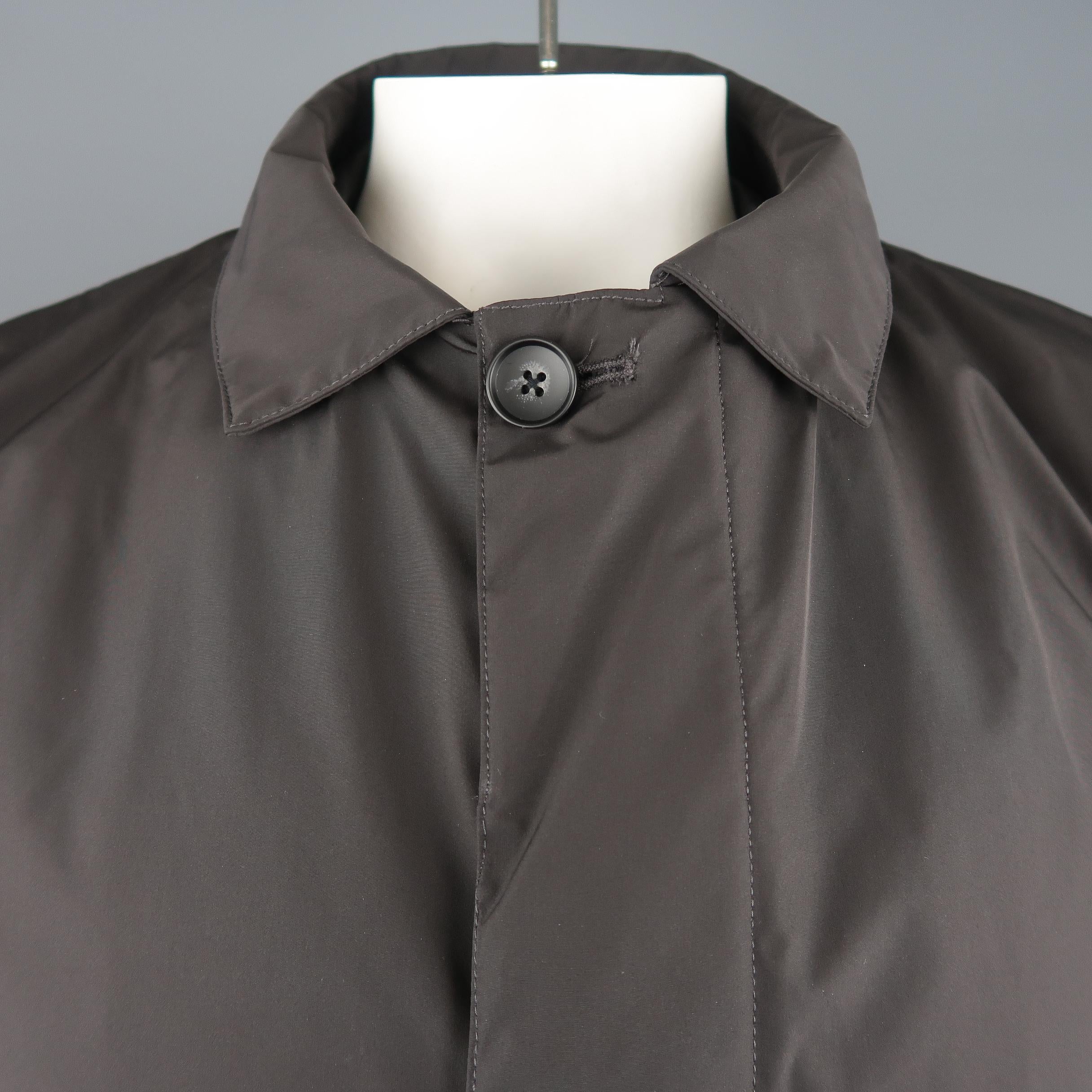 EREDI PISANO raincoat comes in taupe brown waterproof fabric with a pointed collar, zip closure with hidden button placket, slanted zip pockets, button cuffs, and detachable liner that zips into a bomber jacket. Made In Italy.
 
New with Tags.