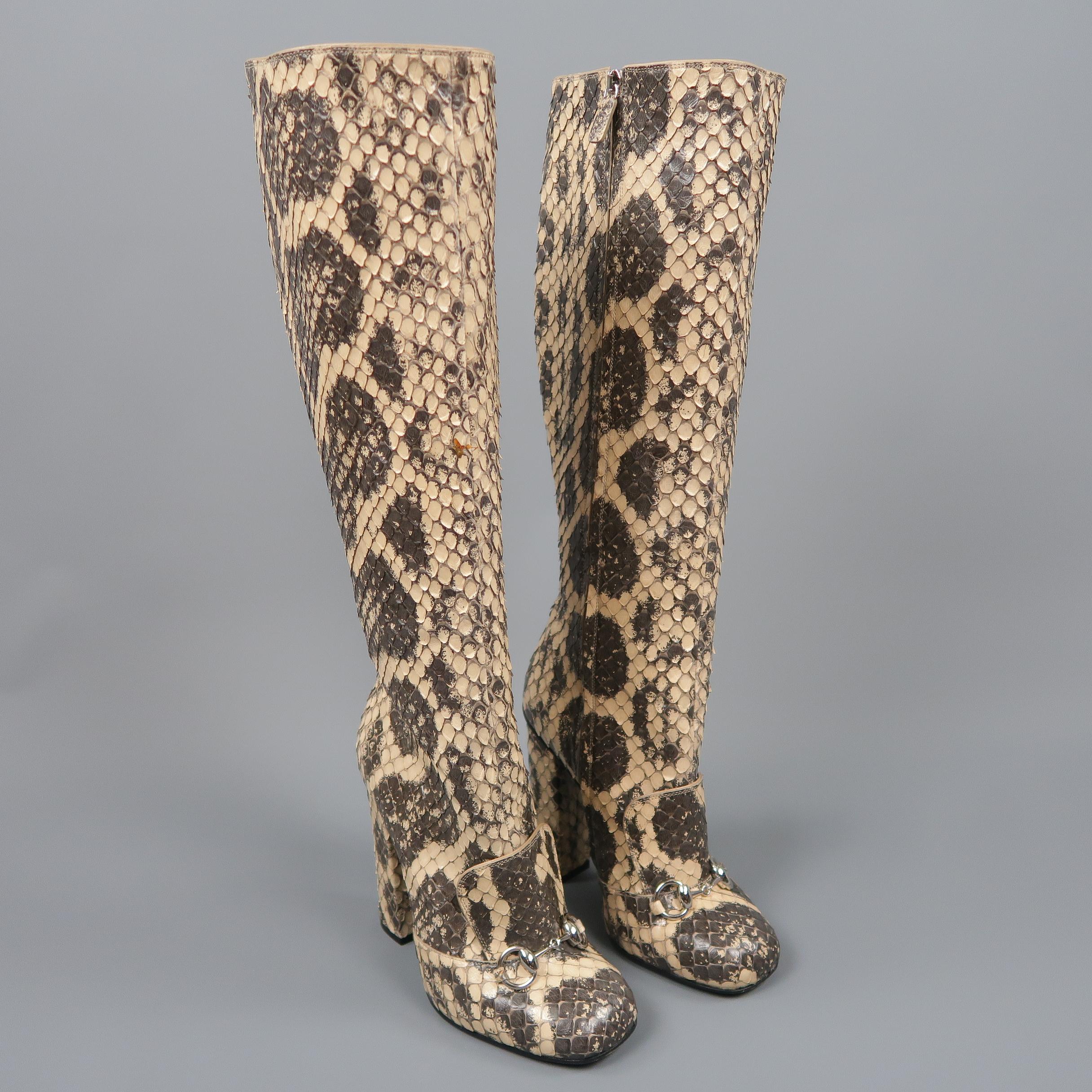 GUCCI knee high boots come in natural beige python skin leather with a rounded square toe, chunky covered heel, and tongue detail with silver tone horse-bit. Spot on right boot. As-is. With box and dust bags. Made in Italy.  Retail Price $3500.00
