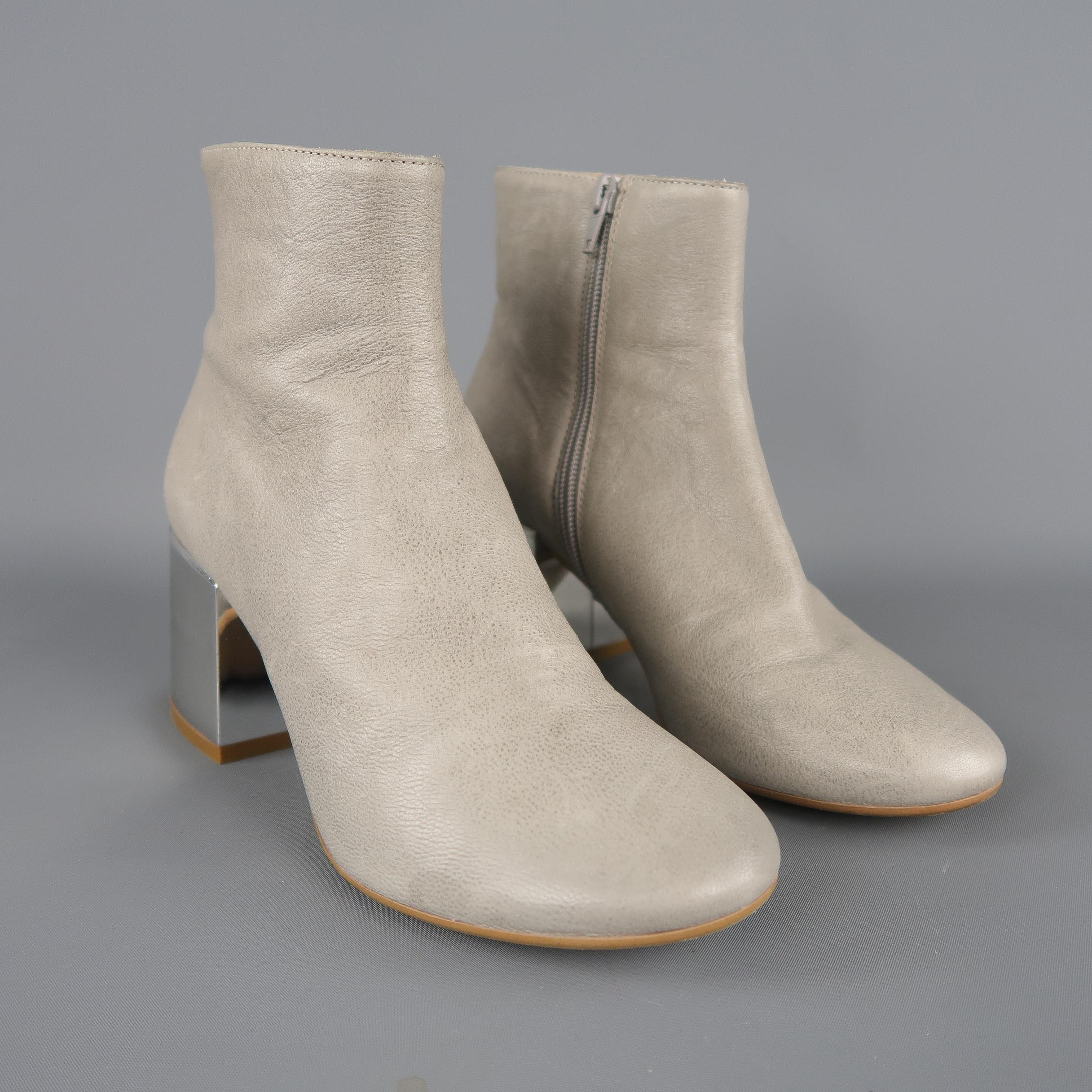 MM6 MAISON MARTIN MARGIELA ankle boots come in gray leather with a round toe and chunky mirrored silver ton chunky heel. Made in Italy. Retail price $799,00.
 
Excellent Pre-Owned Condition.
Marked: IT 38.5
 
Measurements:
 
Heel: 2.85 in.