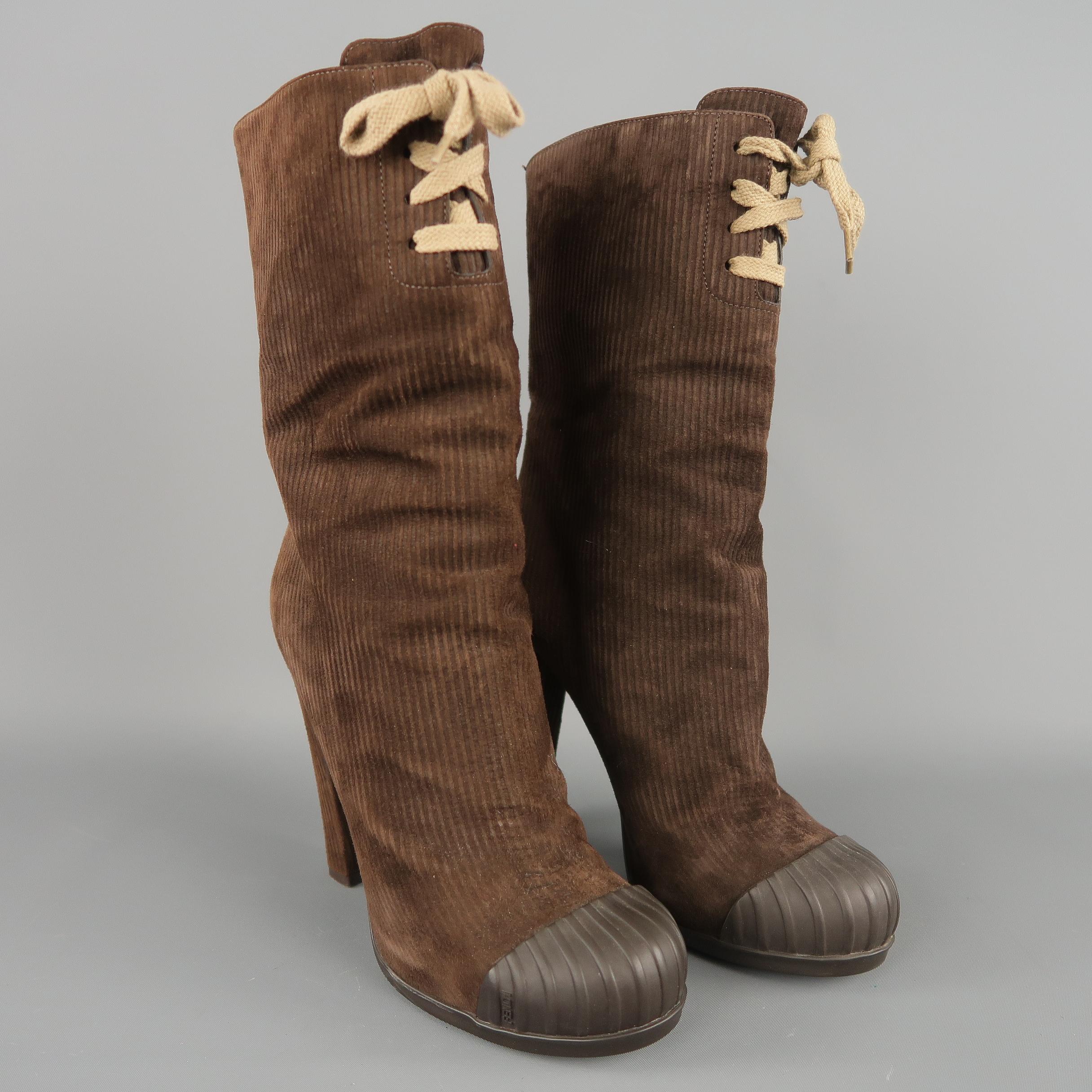 FENDI boots come in corduroy textured suede with a round rubber toe cap, covered chunky heel, and mid calf shaft with tie detail. With box. Made in Italy. Retail price $ 900,00.

 
Good Pre-Owned Condition.
Marked: IT 39
 
Measurements:
 
Heel: 4.75