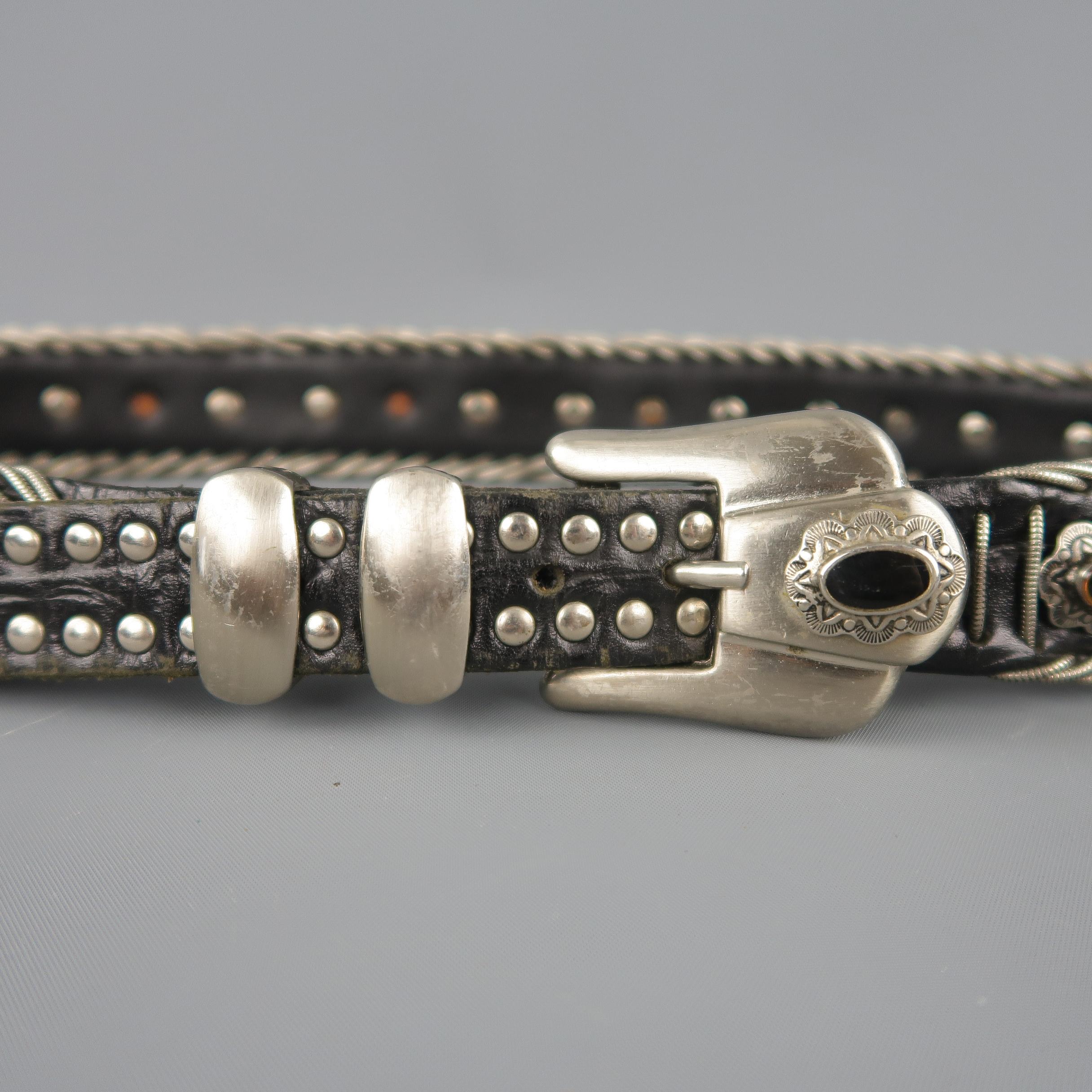 Vintage NAANI Western style belt features a black leather strap with silver metal braided trim and silver studs with black enamel with embellished buckle. Wear throughout. Made in Italy.
 
Good Pre-Owned Condition.
Marked: 85/34
 
Length: 39