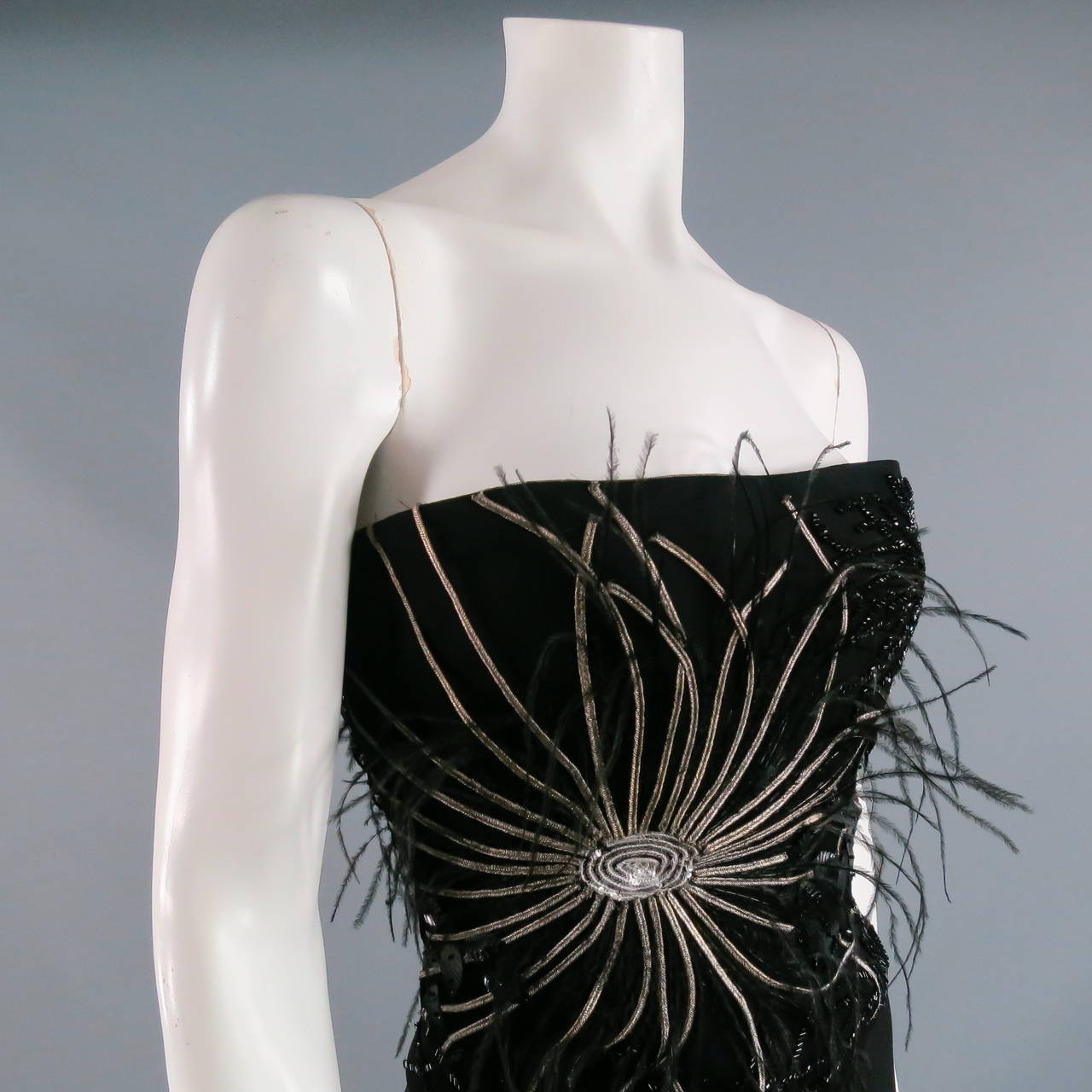 Sexy, stunning strapless dress by RICHARD TYLER.  Full length in black jersey.  Intricate detailing through bodice including beads, feathers and braided, metallic ribbon.  Feathers take on their own whispy movement as you move.  High slit at left. 