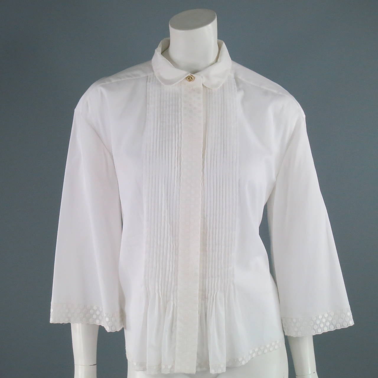 This beautiful oversized CHANEL blouse is made from 100% cotton. Delicate pleated front detail and white polka dot trim.  Made in France.
 
 Excellent Pre- Owned Condition.

Measurements:
Bust- 40 in.
Length of Blouse- 24 1/2 in.
Length of