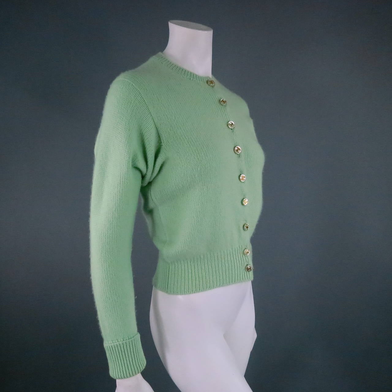 Darling cropped cashmere cardigan by CHANEL. A a fabulous vintage piece in gorgeous mint teal cashmere, featuring a crew neck line, long sleeve with cuffs, and matching pearl buttons with gold 