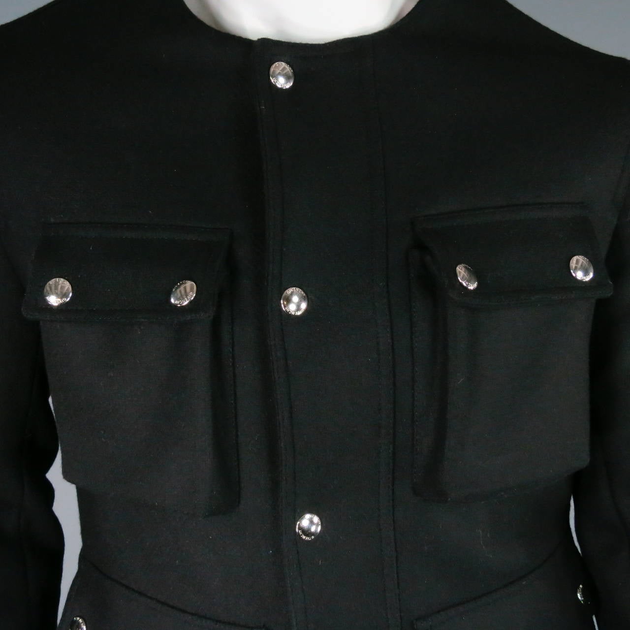 This fantastic Fall 2013 Givenchy jacket features a black wool blend material. Designed with four fully functioning front pockets with snap closures, two side and two inseam pockets with zipper closure. The garment itself, features a snap button