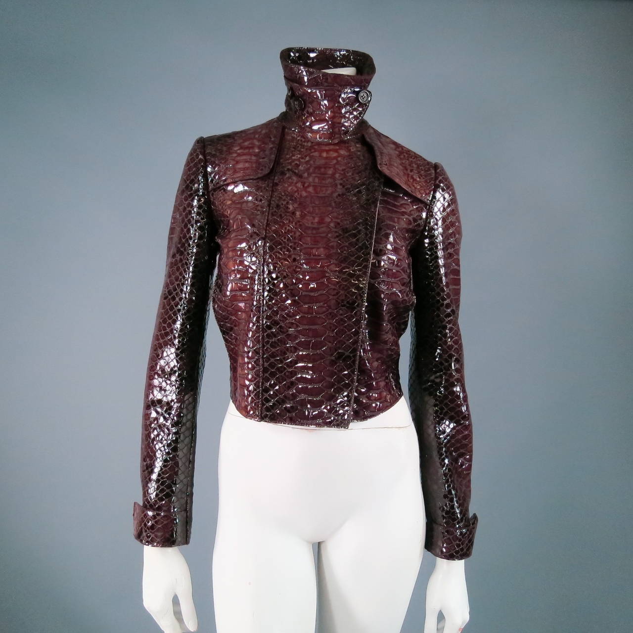 Ultra fierce cropped trench jacket by BURBERRY PRORSUM. A classic style with a major twist this beautiful piece comes in high gloss multi tonal bardeoux patent python leather and features oversized gold snaps and external pockets: Great worn with