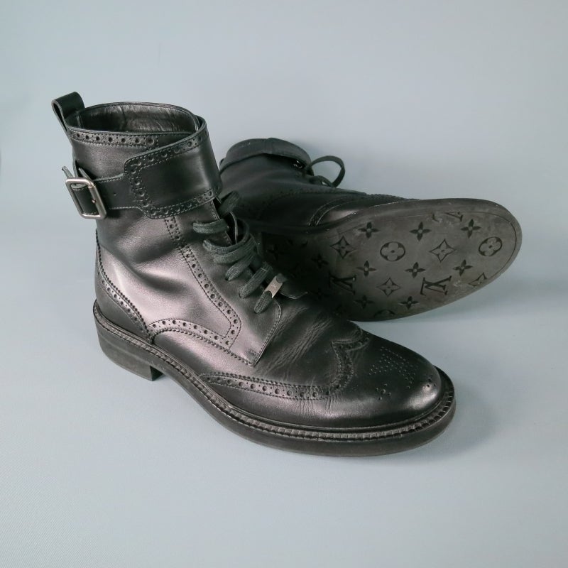 Black leather ankle boot by LOUIS VUITTON.  Perforated LV at front and trimmed continued perforation throughout.  Wingtip, lace up with LV metal hardware.  Belted strap at ankle.  Black monogram rubber sole.  Lightweight and comfortable.  Made in