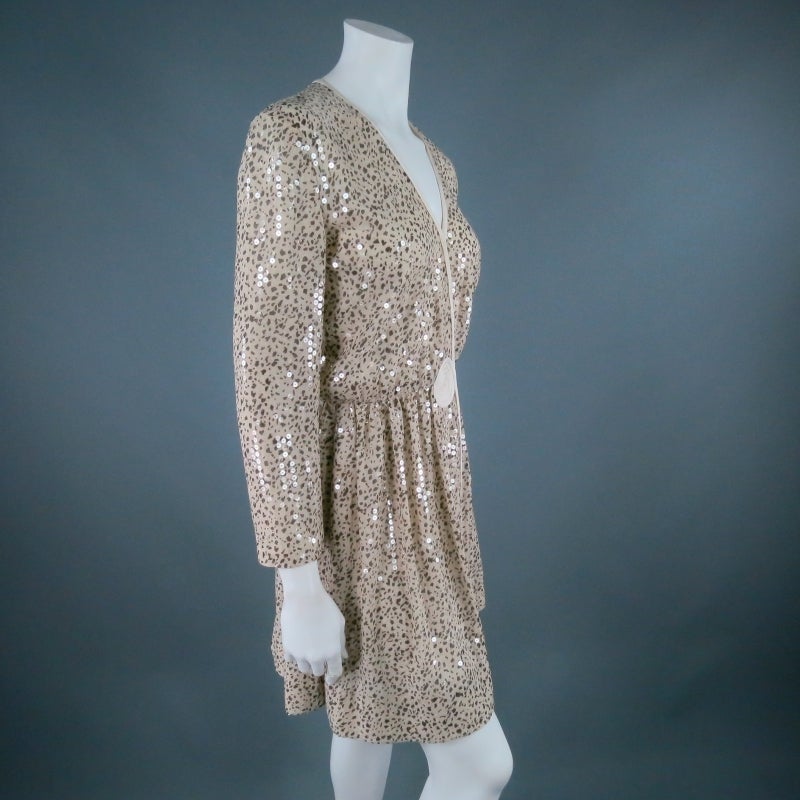 Stunning long sleeve cocktail dress by GIORGIO ARMANI. In a sparkling beige animal print chiffon with clear sequin overlay, this wrap style, features an adjustable snap V neckline, gathered waist; and swirl embellishment with matching piping. A