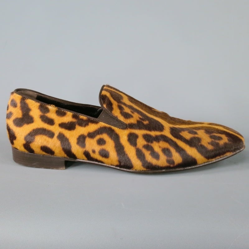Yves Saint Laurent slip-on Loafer consists of pony hair material with contrast brown sole. Designed with animal print pattern, light tones of brown and dark brown can be seen throughout shoe. Brown pipping along edge of shoe can be seen towards shoe