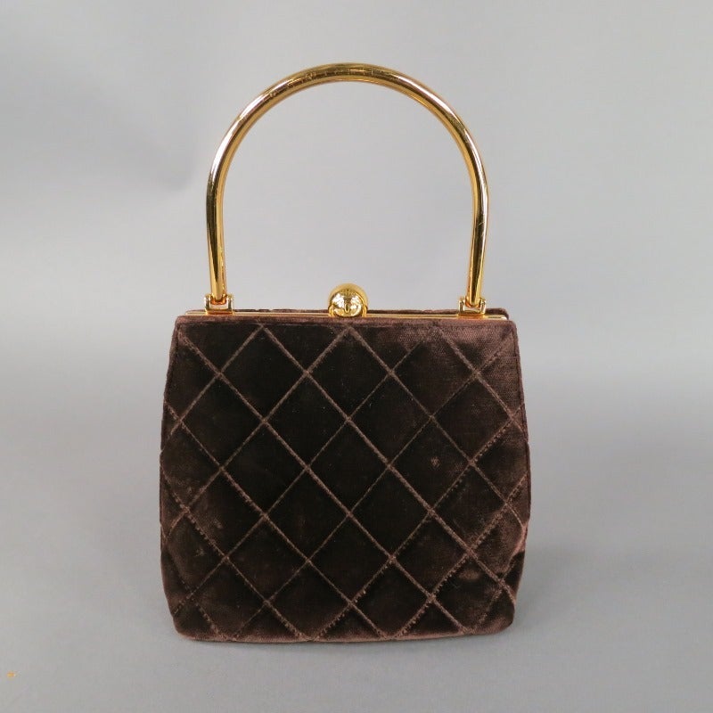The perfect little purse by CHANEL.  Single gold tone top handle; hinges open with dome shape CC clasp into a shiny leather gold interior with single zipper pocket and the perfect amount of room for the essentials.  Exterior is a chocolate quilted