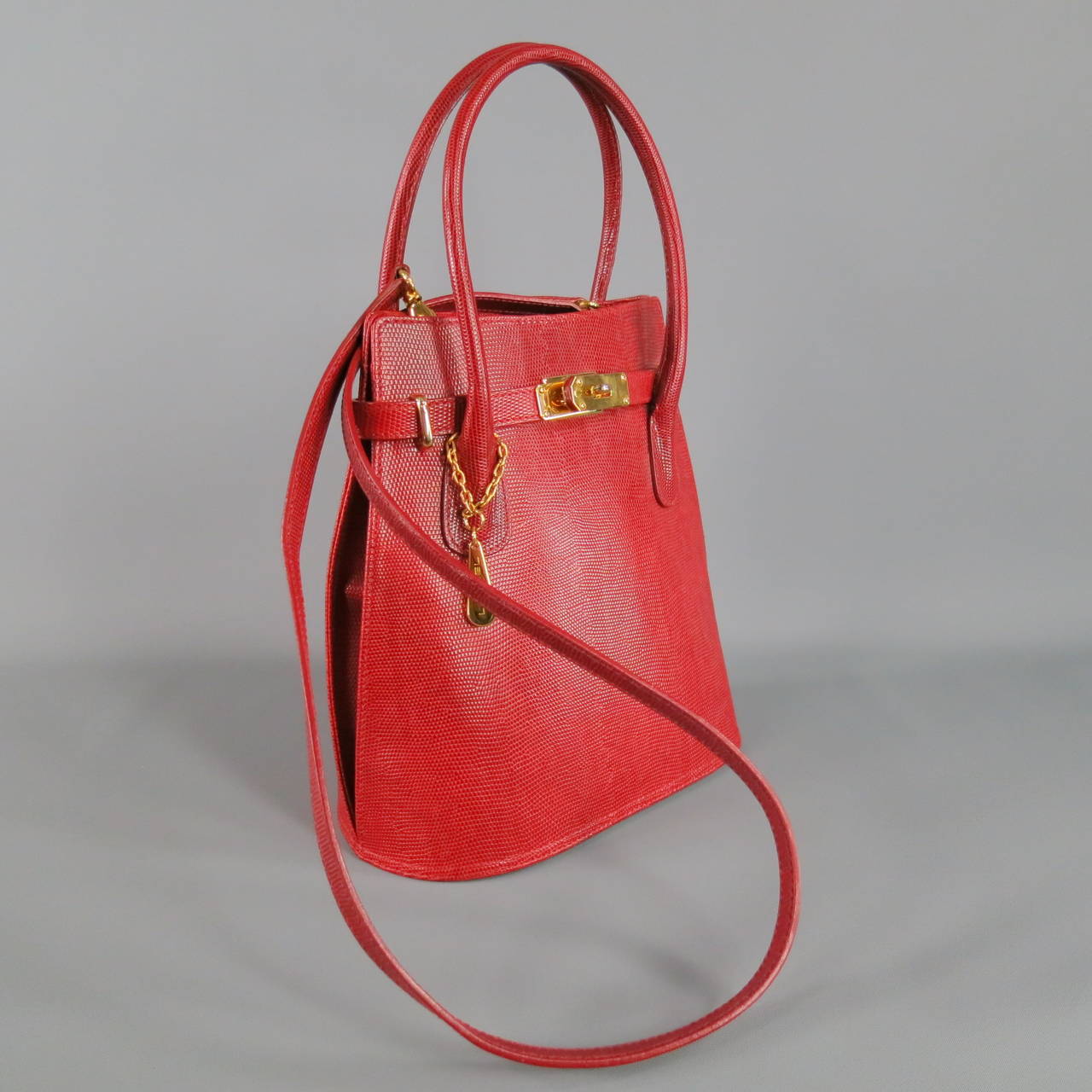 Gorgeous vintage LANCEL bag with detachable thin strap cross body option.  Standing top handles.  Flat bottom and pear shaped; lizard embossed sturdy red leather.  Shiny gold metal hardware.  Lancel fabric interior with zipper pocket.  Made in