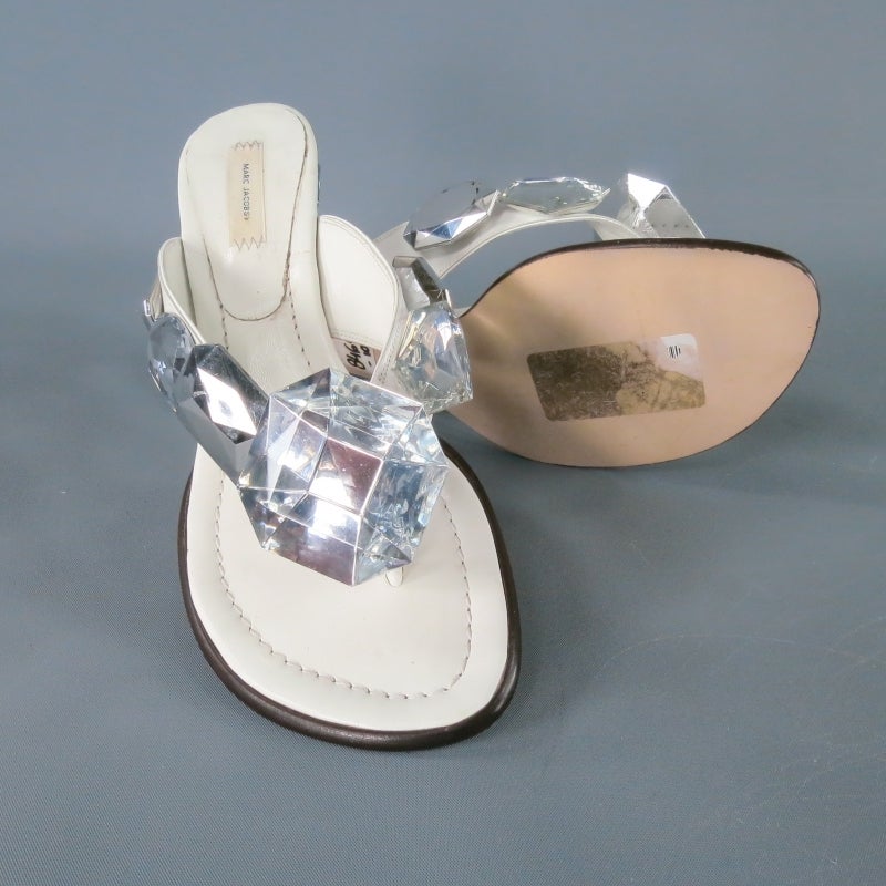White leather sandals by MARC JACOBS. A super fun style in white leather, featuring a thong strap embellished with oversized gems and diamond jewel pop art heel. A fabulous statement piece for your spring/summer wardrobe. With Box. Made in Italy.
