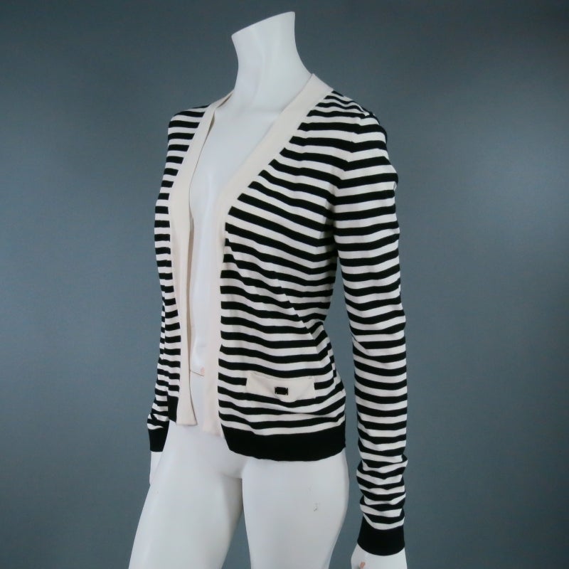 Classic knit cardigan by Chanel 2005, in a high contrast cream and black stripe featuring symmetrical patch pockets and thick cream piping. A timeless style for everyday wear. Made in France.

Excellent Pre-Owned Condition.

Measurements:

Shoulder: