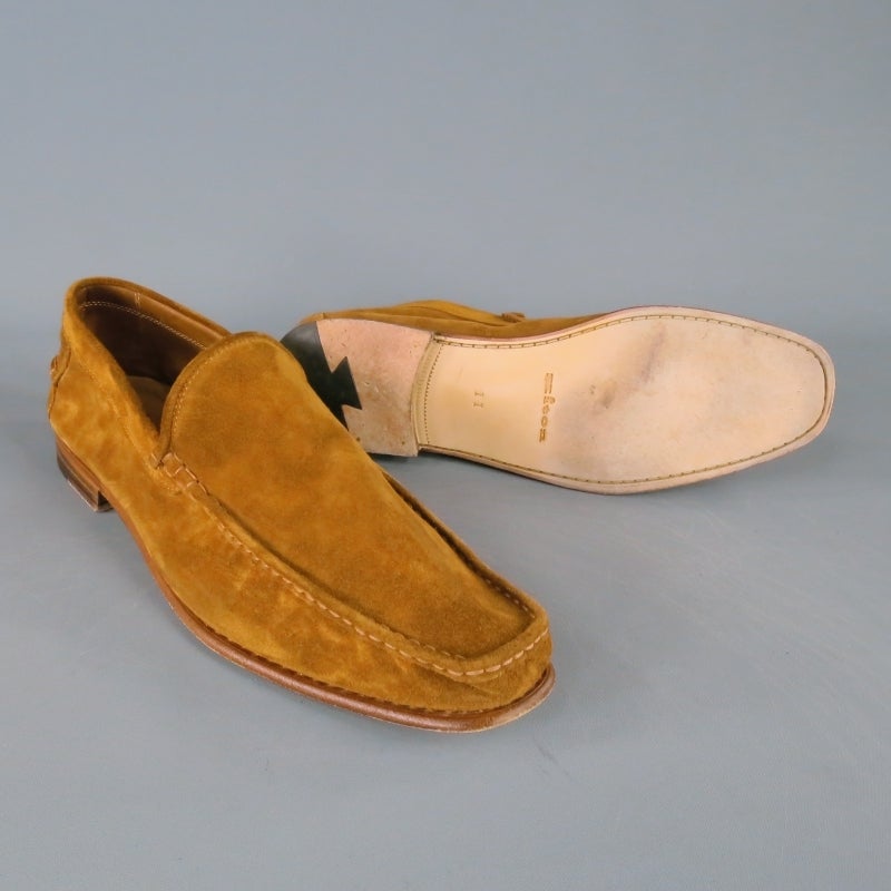 KITON Slip On Loafers consists of a suede material in a tan tone. Designed with a top stitched apron toe with tone-on-tone stitching throughout top edge of shoe. Contrast brown leather sole accents color of material. Made in Italy.
 
Fair