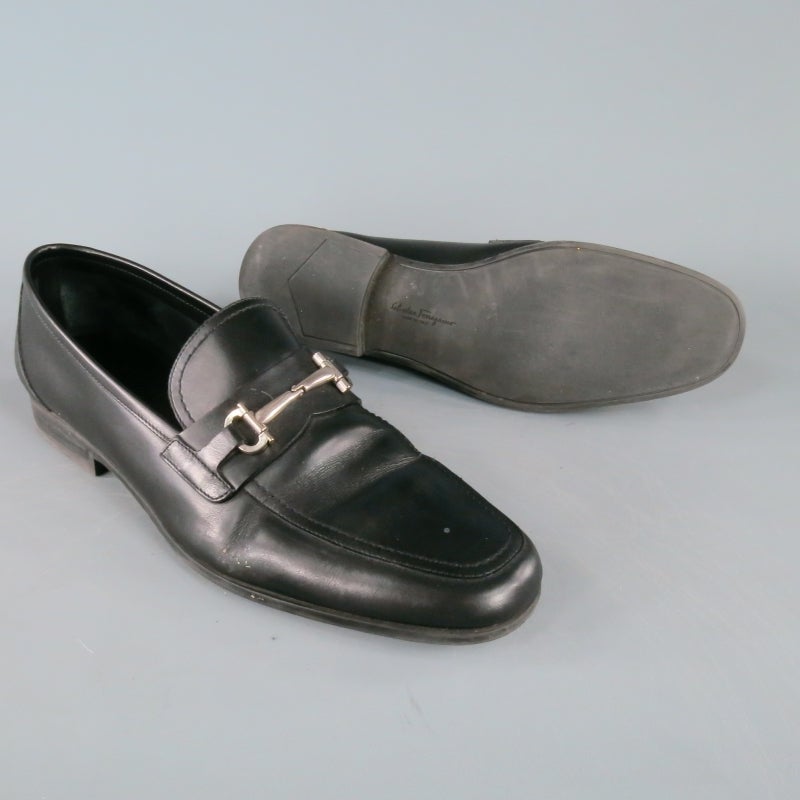 Salvatore Ferragamo Slip On Loafer consists of a leather material in a black color tone. Designed with signature silver-tone double Gancio-bit accent, leather lining and rubber sole for secure grip. Tone-on-tone stitching can be seen throughout