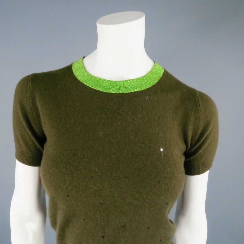 Cropped pullover by CHANEL. A fun style in olive sequin cashmere featuring a green Lurex sparkle knit collar and "CC" button back closure. Made in UK.

Excellent pre-Owned Condition.

Measurements:

Shoulder: 15 in.
Bust: 36