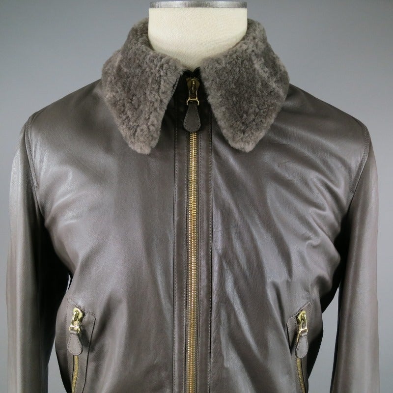 BOTTEGA VENETA Bomber style Leather Jacket comes with a detachable fur collar.  Gold zip front closure and pockets.  Large buttons at cuffs.  Heavy Ribbing at waist.  Warm lining includes a wool/cashmere blend in black and gray flannel pattern. 