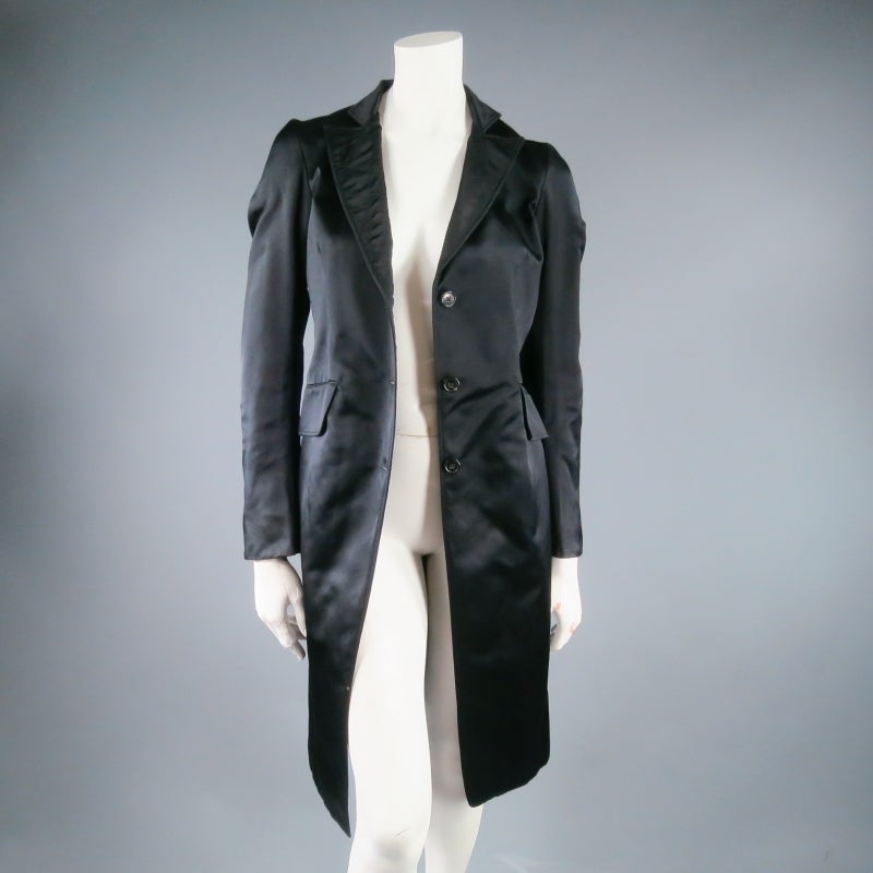 Gorgeous black silk satin coat by JIL SANDER. A classic style with modern minimalist appeal, this piece features a tailored fit in luxurious material, a utility quilted peak lapel, and comes with a textured waist belt to tie. A great piece for day