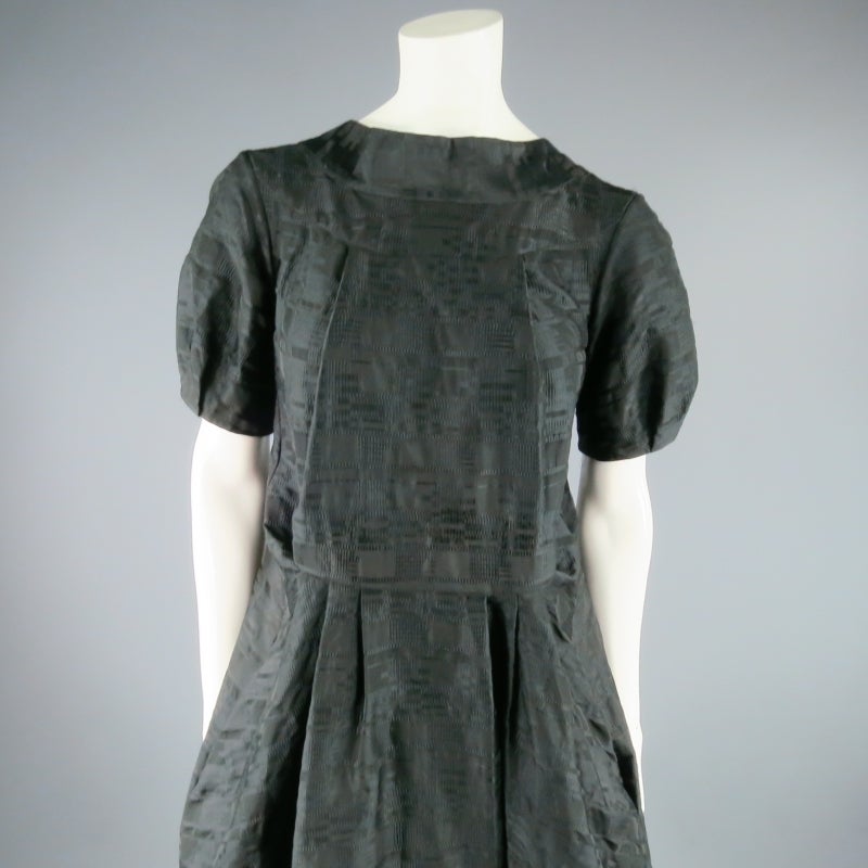 Fun avant garde cocktail dress by MARNI. A chic style in geometric textured fabric you can wear two different ways featuring a short puff sleeve, pleat details, and a deep V with bow detail. Made in Italy.
 
Excellent Pre-Owned Condition.
