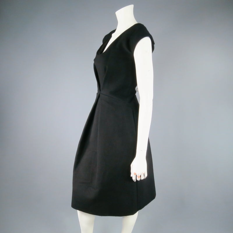 Gorgeous black wool cocktail dress by MARC JACOBS. A sleeveless style, impeccably structured with V darts and box pleating, featuring a low scoop neck line with sparkling black bugle beading and exposed gold back zip detail. Made in the USA.
