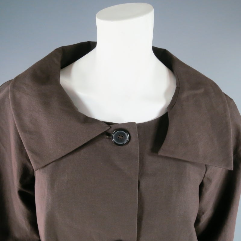 Three button A-line jacket by MARNI. A classic style in light weight brown cotton featuring a cape like silhouette and asymmetrical collar. Made in Italy.
 
Excellent Pre-Owned Condition.
 
Measurements:
 
Shoulder: 18 in.
Bust: 40