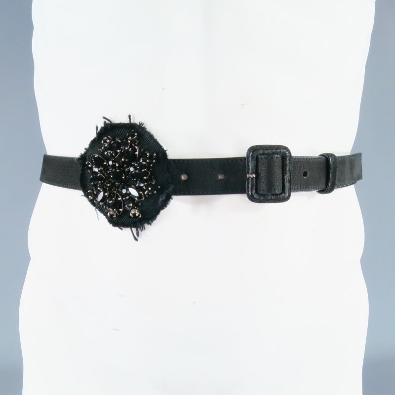 Gorgeous Black leather waist belt by PRADA. A classic skinny belt with covered buckle featuring a black raw edge denim flower patch with sparkling black rhinestone crystal jewel embellishments. Made in Italy.
 
Excellent Pre-Owned Condition.
