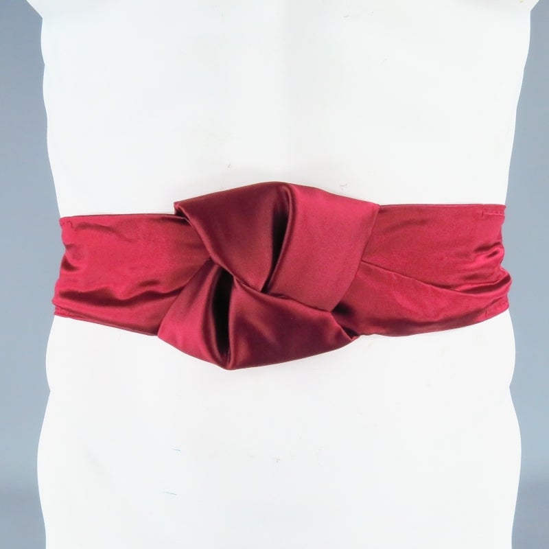Burgundy silk waist belt by PRADA featuring a decorative tied knot, elastic back, and adjustable snap closure. Spring/Summer 2007 Collection.Made in Italy.
 
Excellent Pre-Owned Condition.
 
Measurements:
 
Length: 33 in.
Width: 4 in.