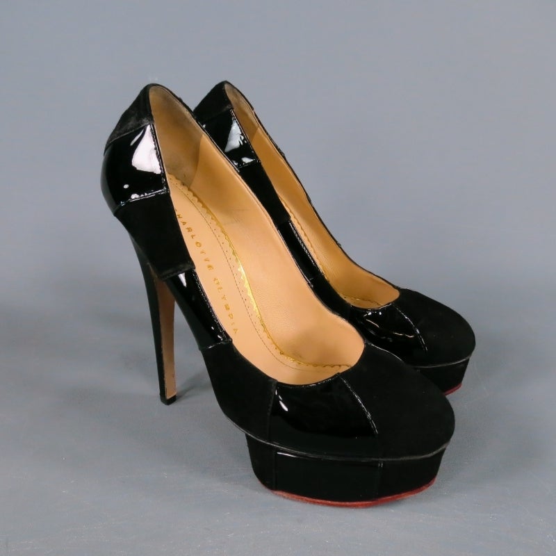 Fabulous high heeled platform pumps by CHARLOTTE OLYMPIA. A classic style taken to the next level, this fierce shoe comes in a black suede and glossy patent leather stipe and features a thick glossy stiletto heel, curved point toe, and thick